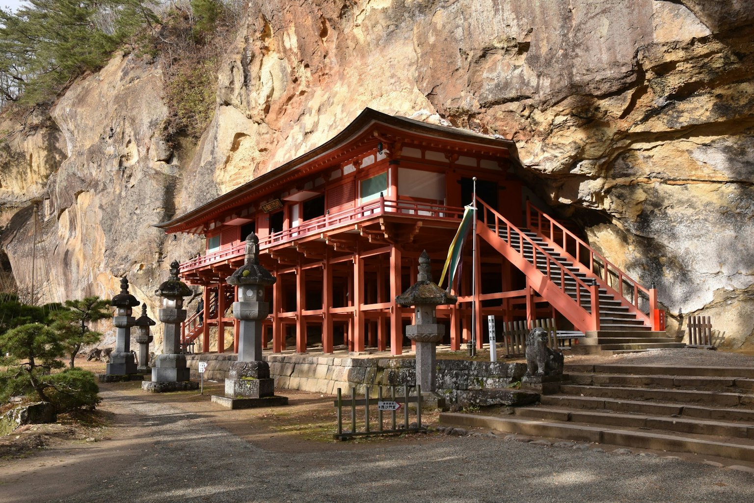 懸崖旁的紅色寺廟和石像