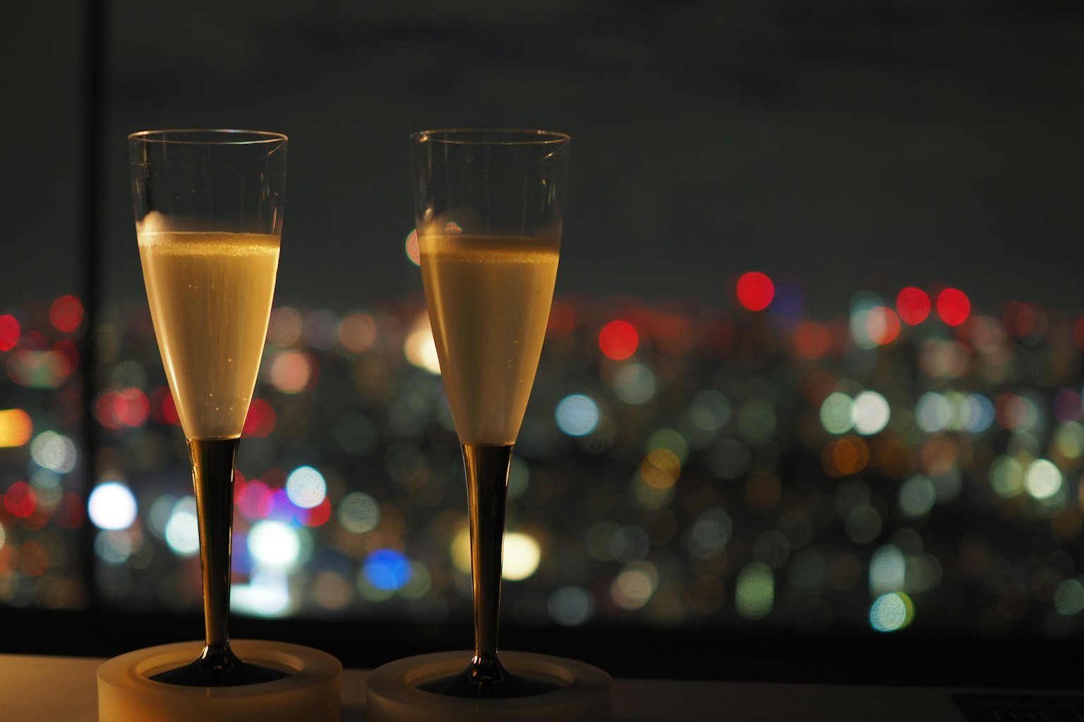 Due bicchieri di champagne contro uno skyline notturno