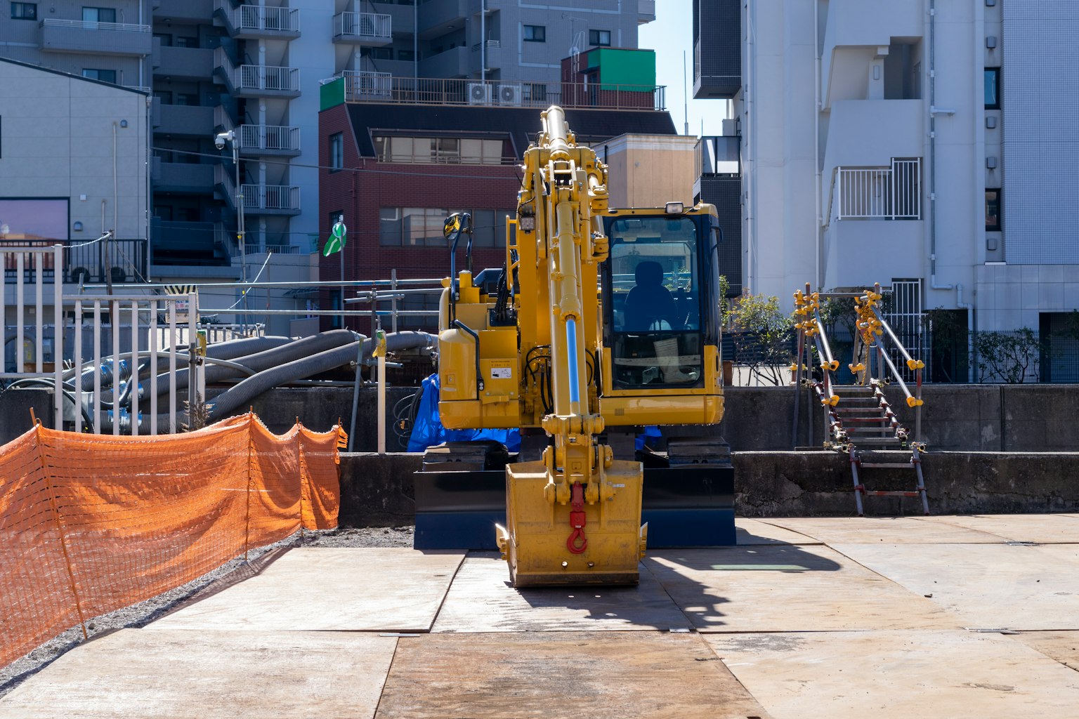 รถขุดสีเหลืองที่ไซต์ก่อสร้างในเมือง