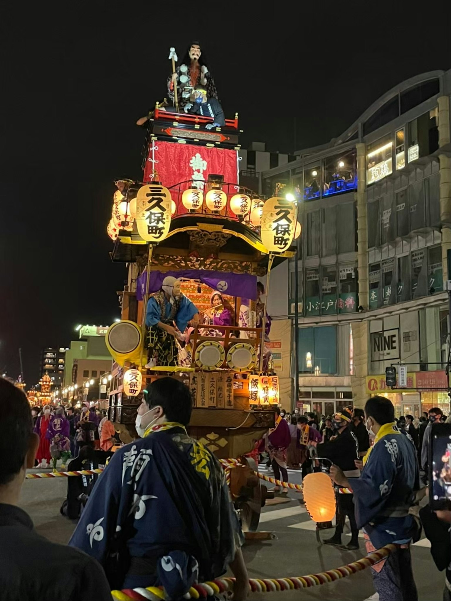 밤에 활기찬 도시 거리에서 행진하는 축제 플로트