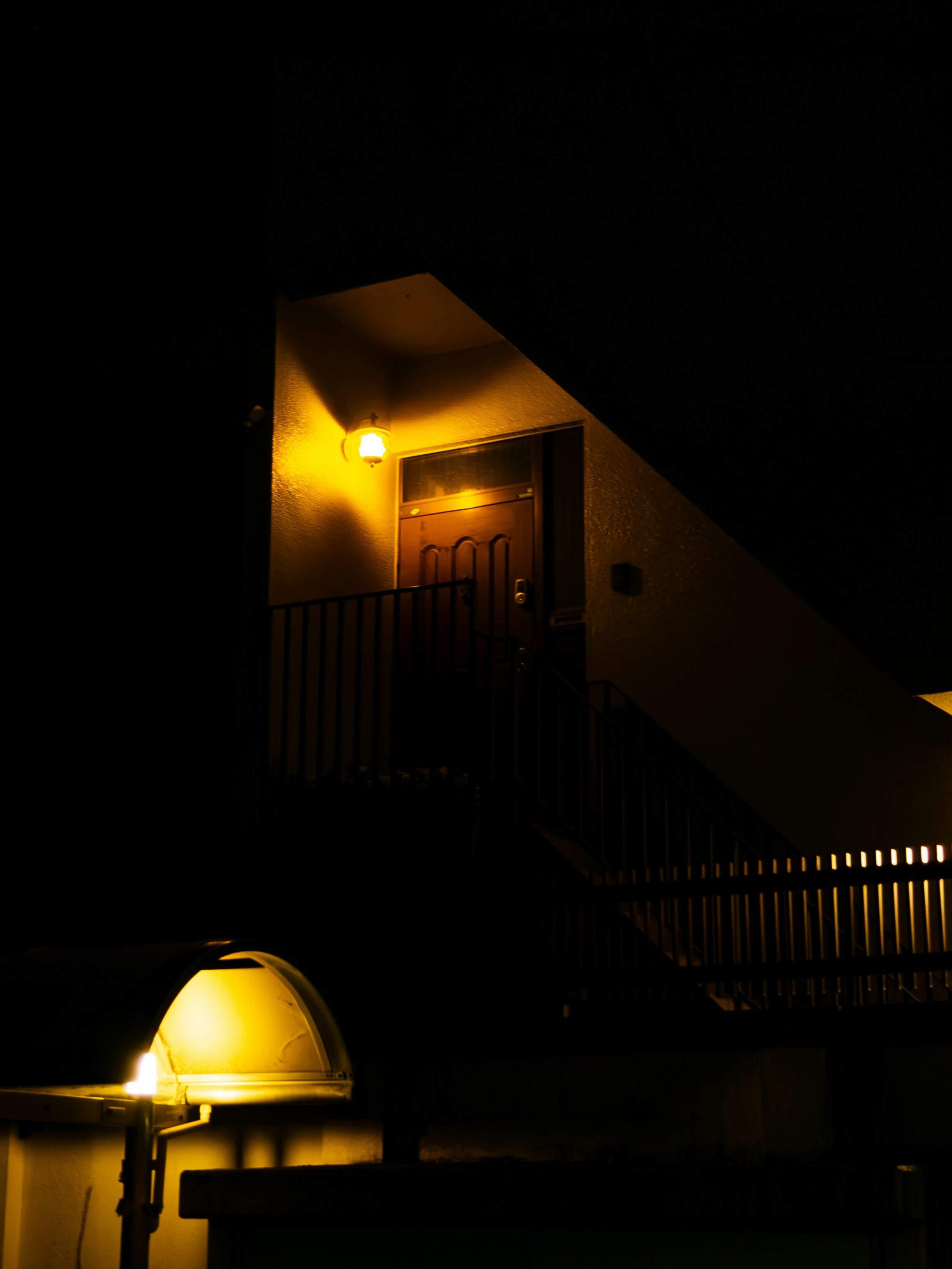 ingresso di casa di notte con gradini illuminati e porta