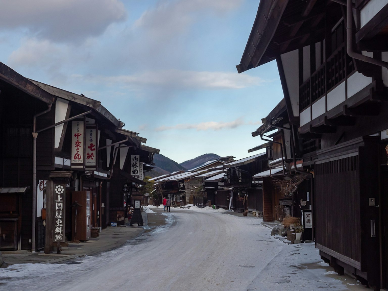 被雪覆蓋的街道，兩旁是傳統木製建築