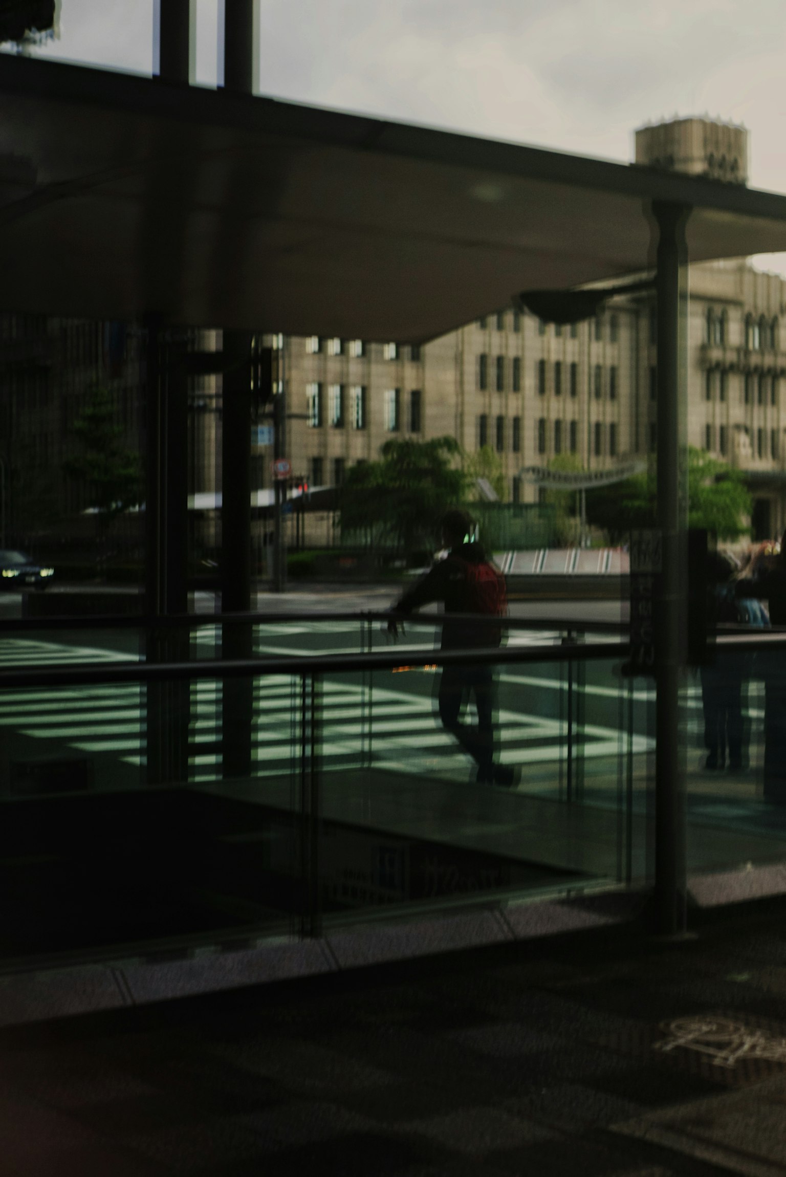 Reflection of a glass building with a person crossing the street