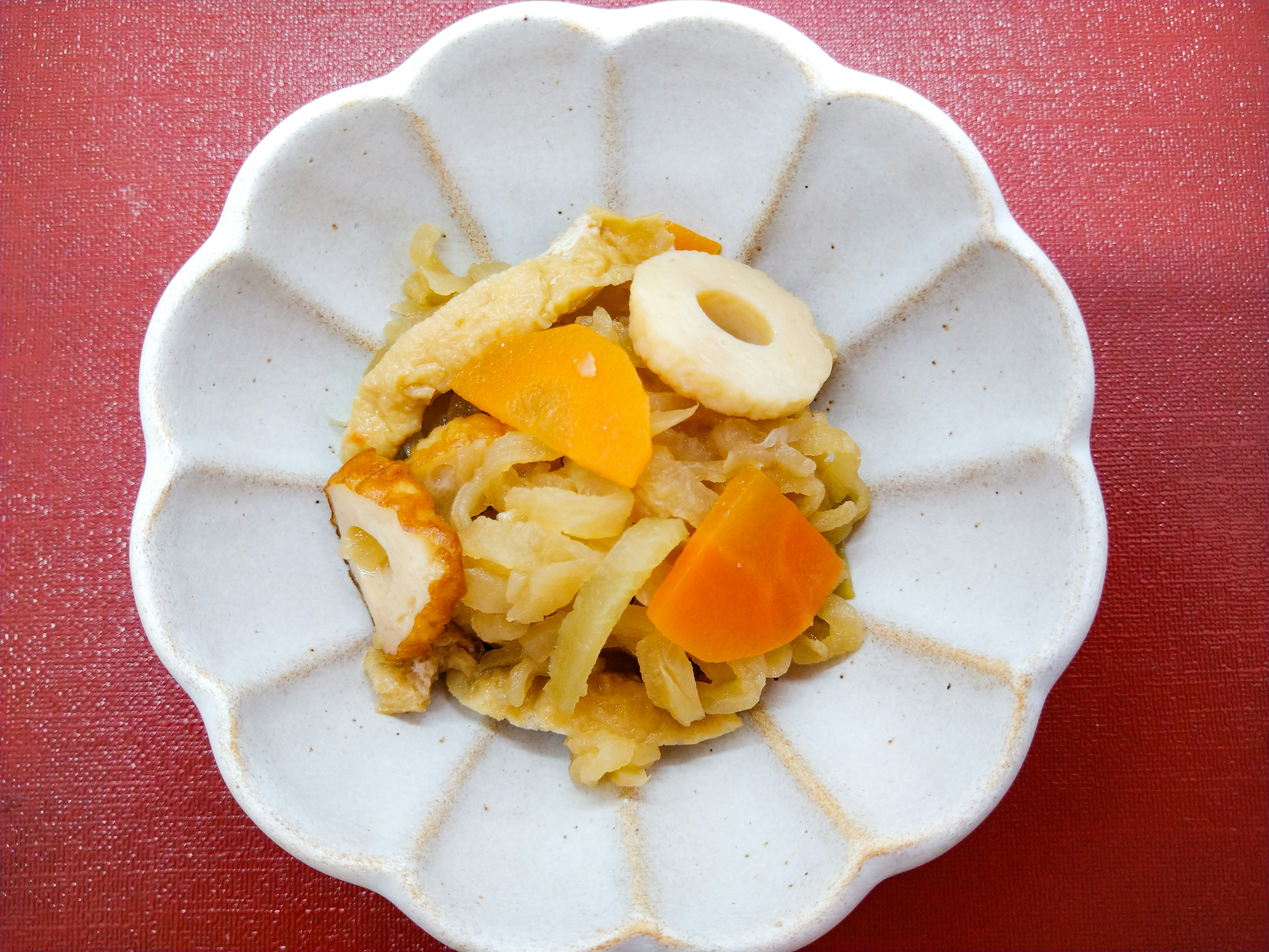 赤い布の上に盛られた野菜と卵の炒め物