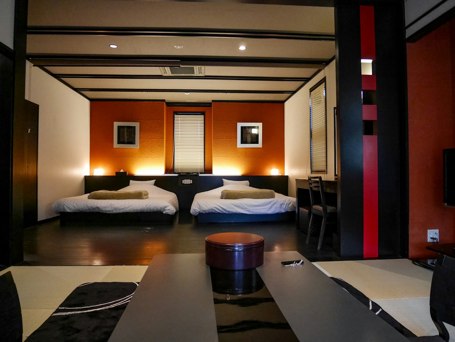 Moderne japanische Gästezimmer mit Futons auf dem Boden orange und weiße Wände einfache Möbel