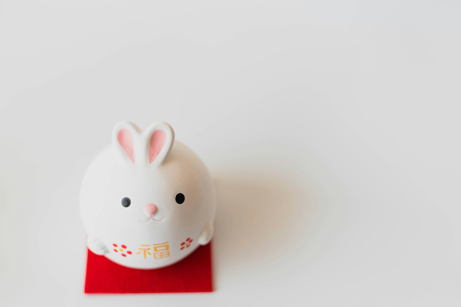 A white rabbit figurine placed on a red mat