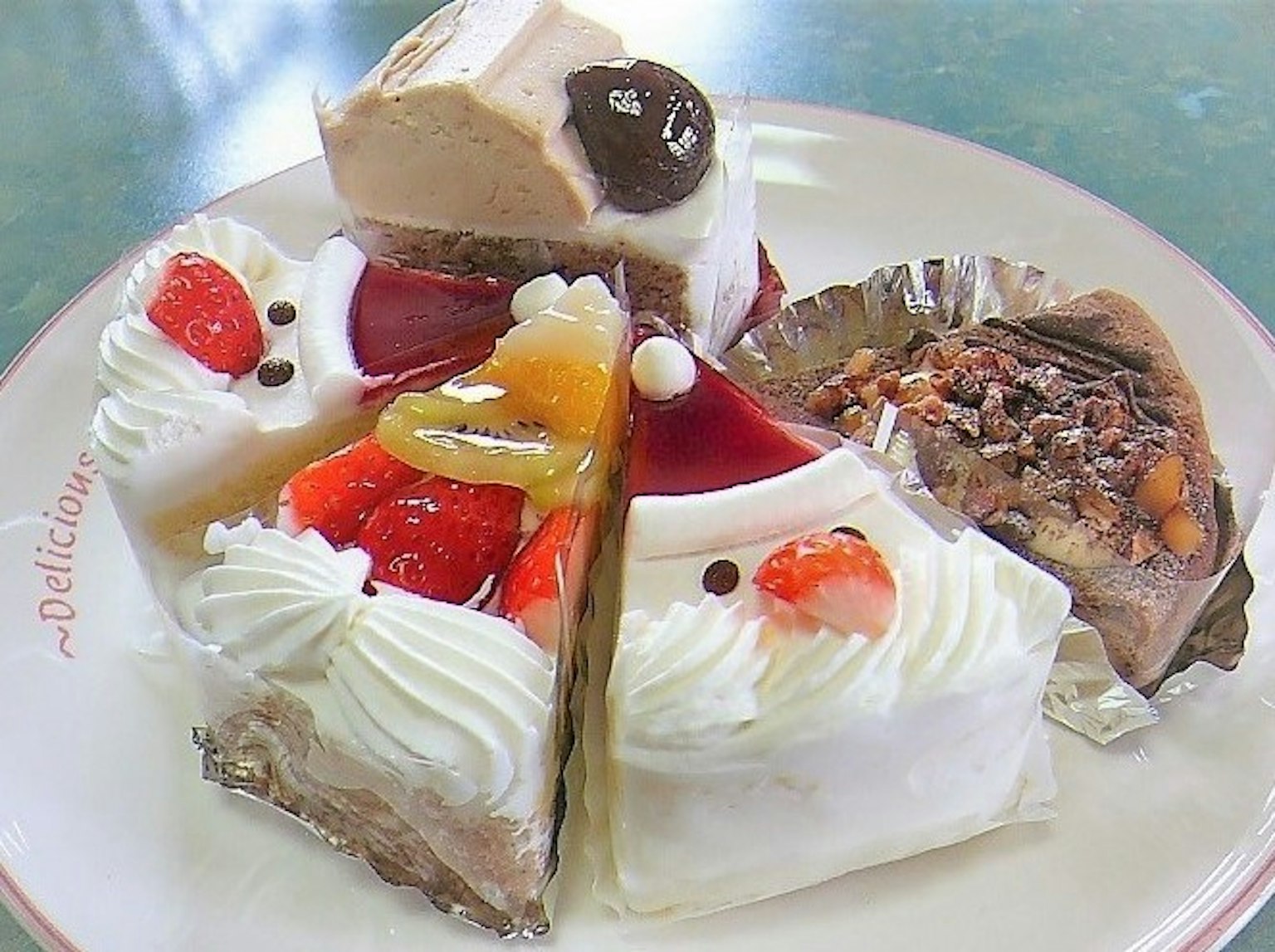จานที่มีขนมหวานหลากสีพร้อมเค้กและท็อปปิ้งต่างๆ