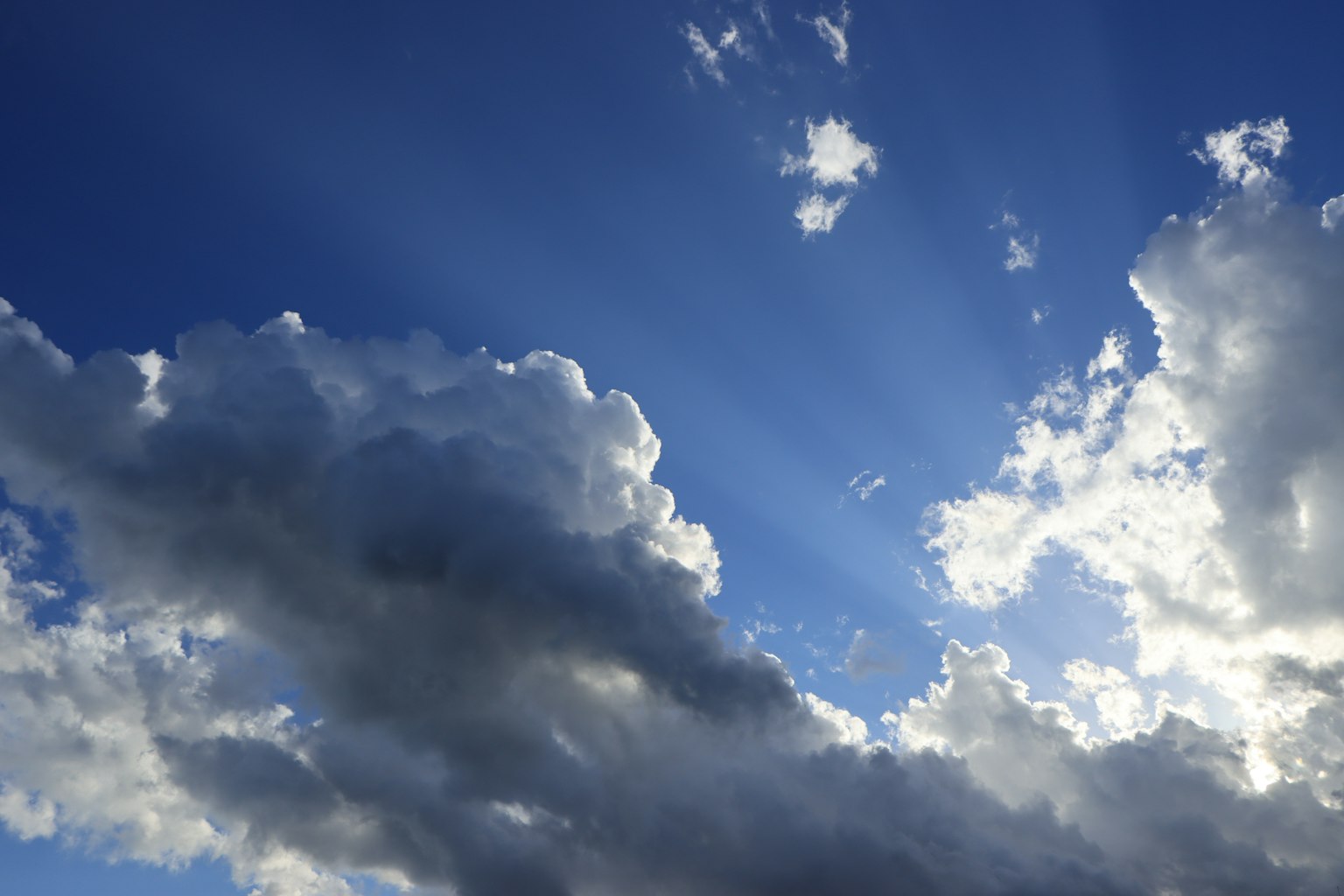 Szenische Aussicht auf den blauen Himmel mit Lichtstrahlen, die durch die Wolken scheinen