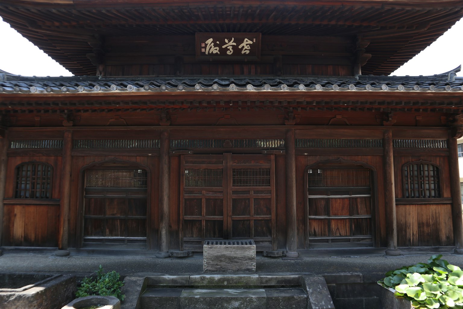 傳統木建築的正面外觀 具有窗戶和門 舊式屋頂和漢字標誌