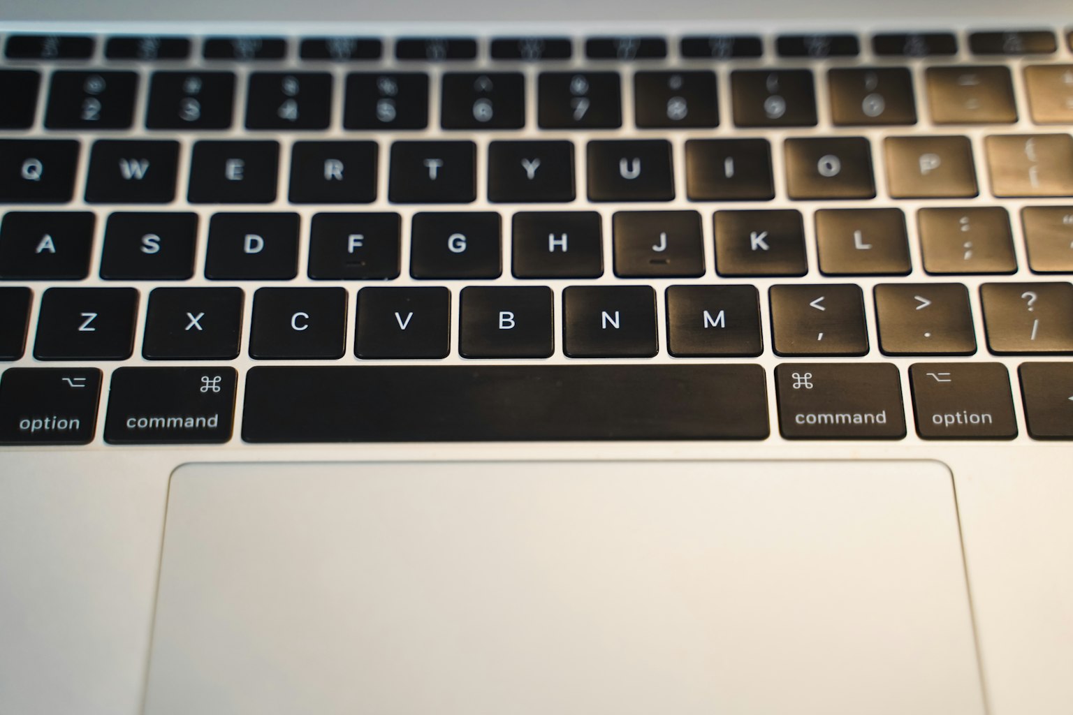 Close-up of a black laptop keyboard with a touchpad