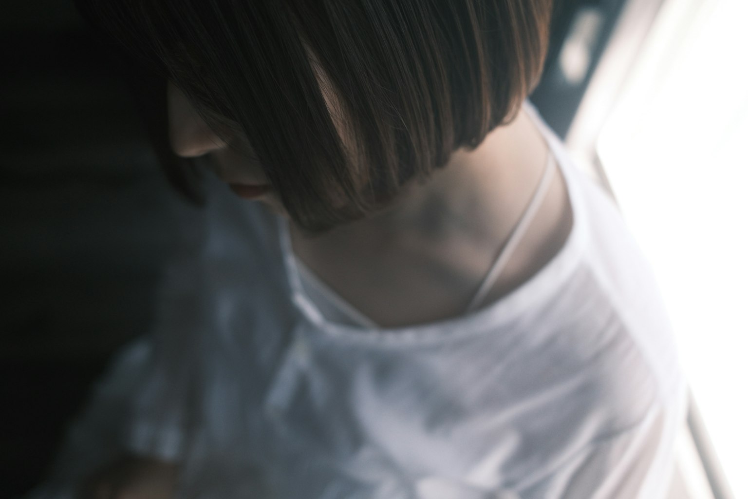 女性が窓の近くで白い服を着ている姿の上からのショット