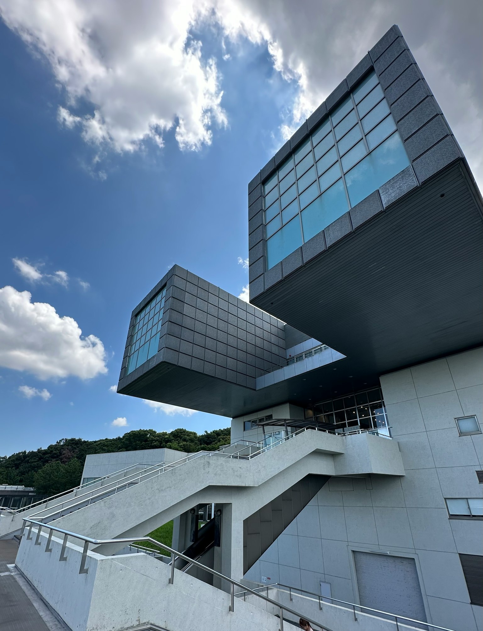 Moderne Architektur mit zwei überlappenden Würfeln blauer Himmel und weiße Wolken im Hintergrund