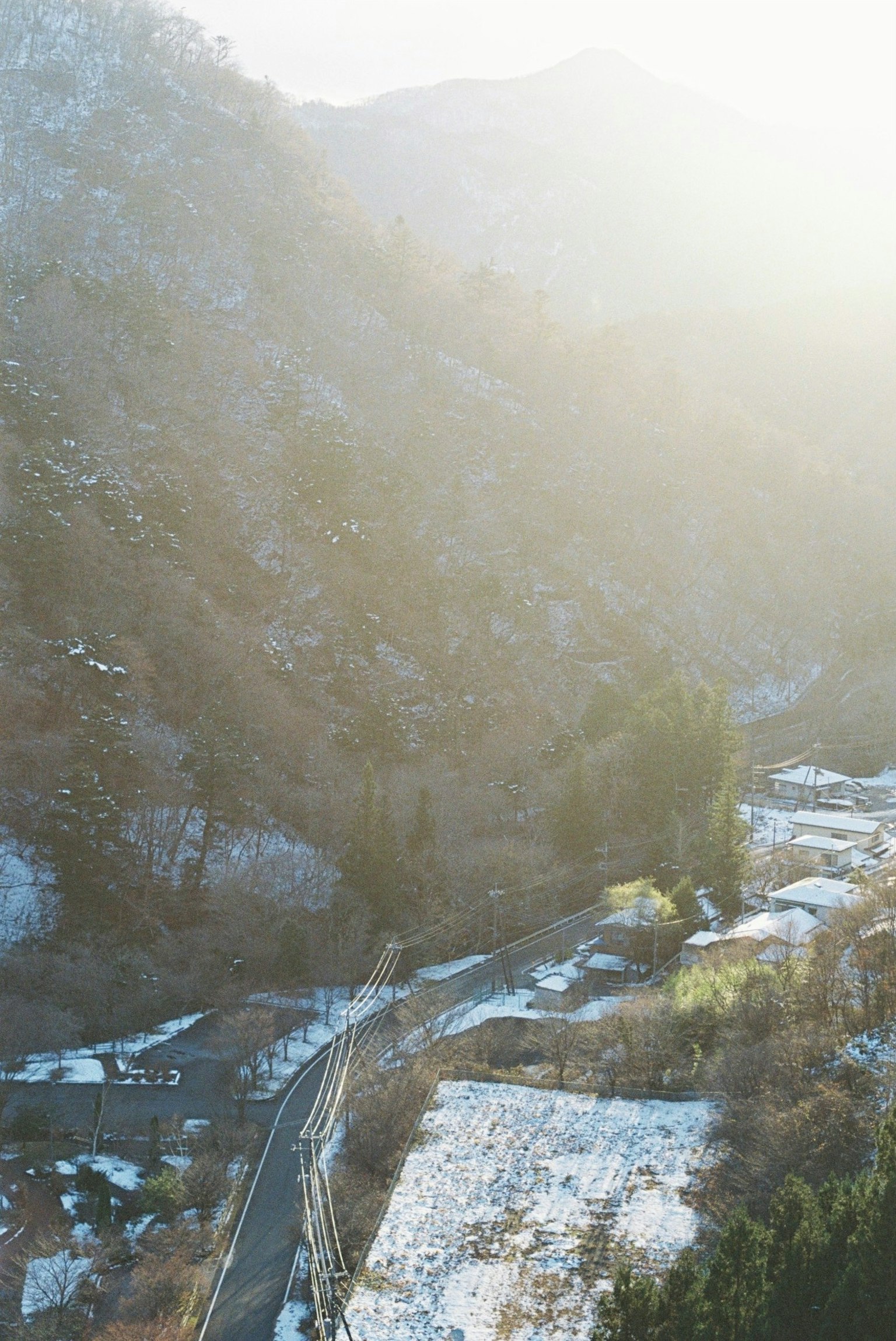 Snow-covered valley landscape with morning sunlight