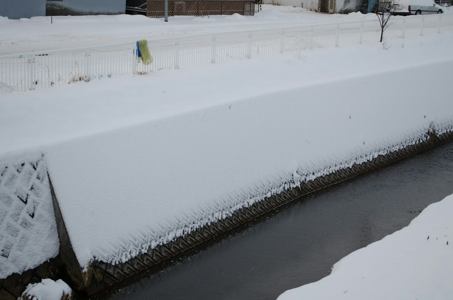 被雪覆盖的堤岸和流动的水