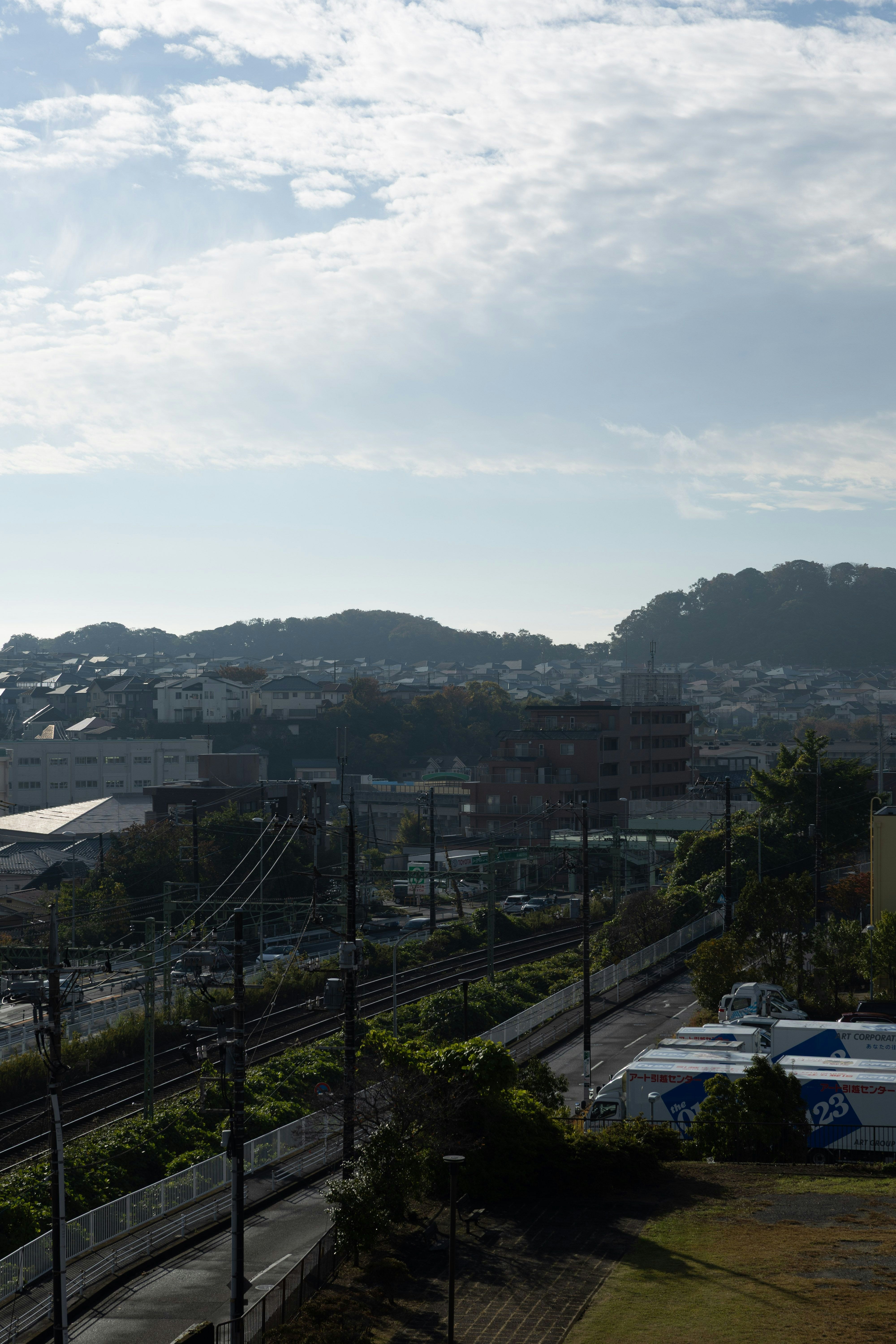 丘陵の向こうに広がる住宅地と高架のある街並み