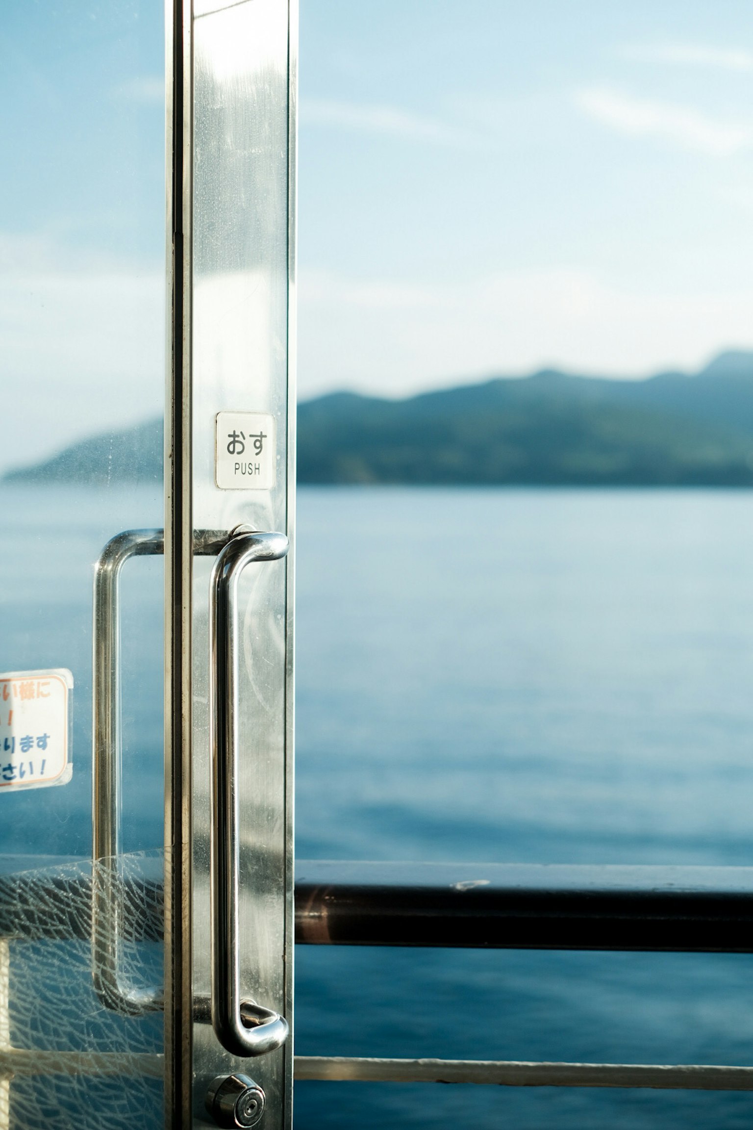 Close-up pintu logam dengan latar belakang laut