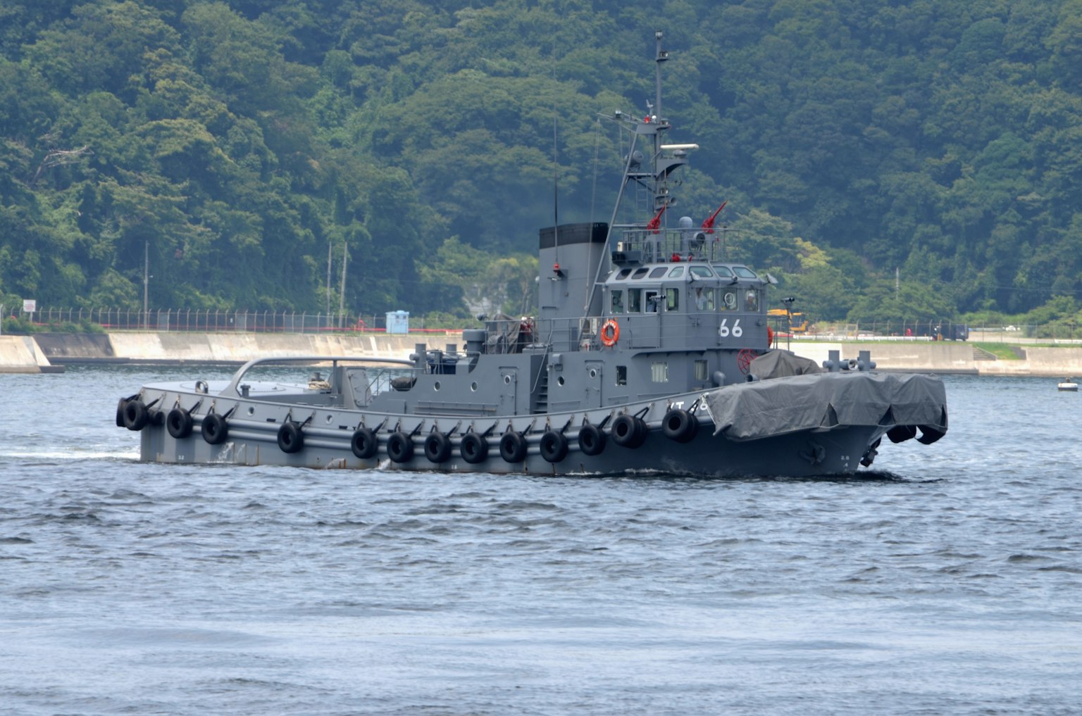 在水上航行的灰色軍艦，背景為綠色