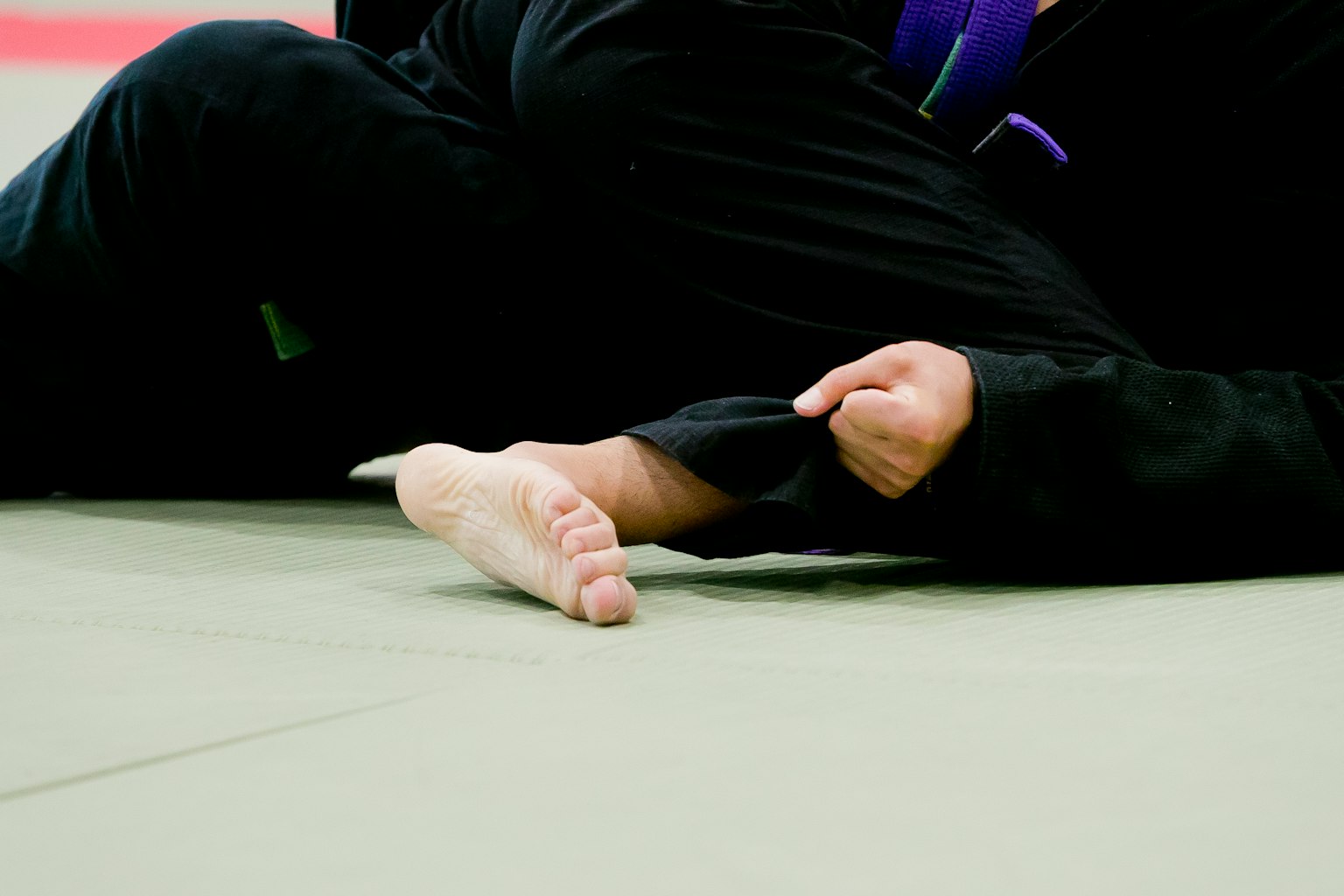 Close-up of a foot and hand during a judo match