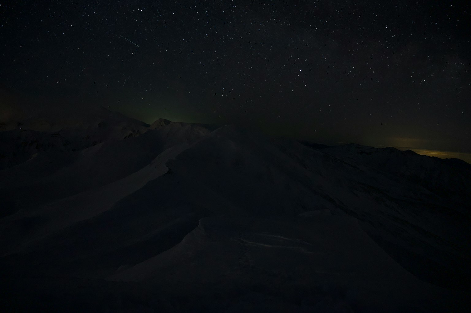 Silueta de montañas oscuras bajo un cielo estrellado