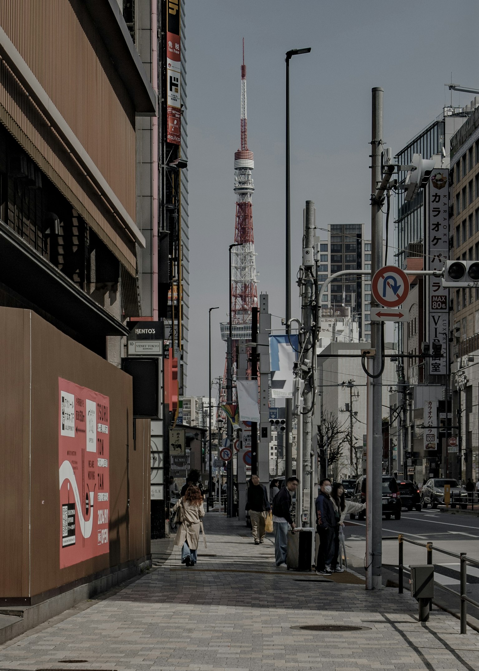 Pemandangan jalan dengan Menara Tokyo di latar belakang orang-orang berjalan