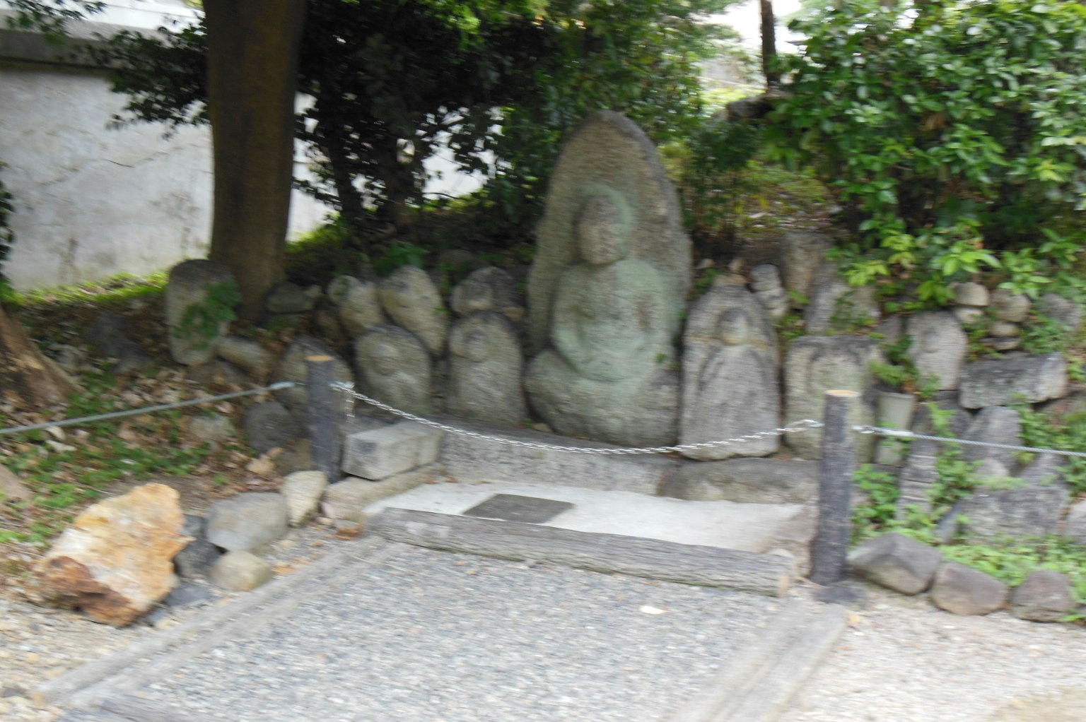 Scena di giardino sereno con statue di Buddha in pietra una grande statua centrale circondata da figure più piccole
