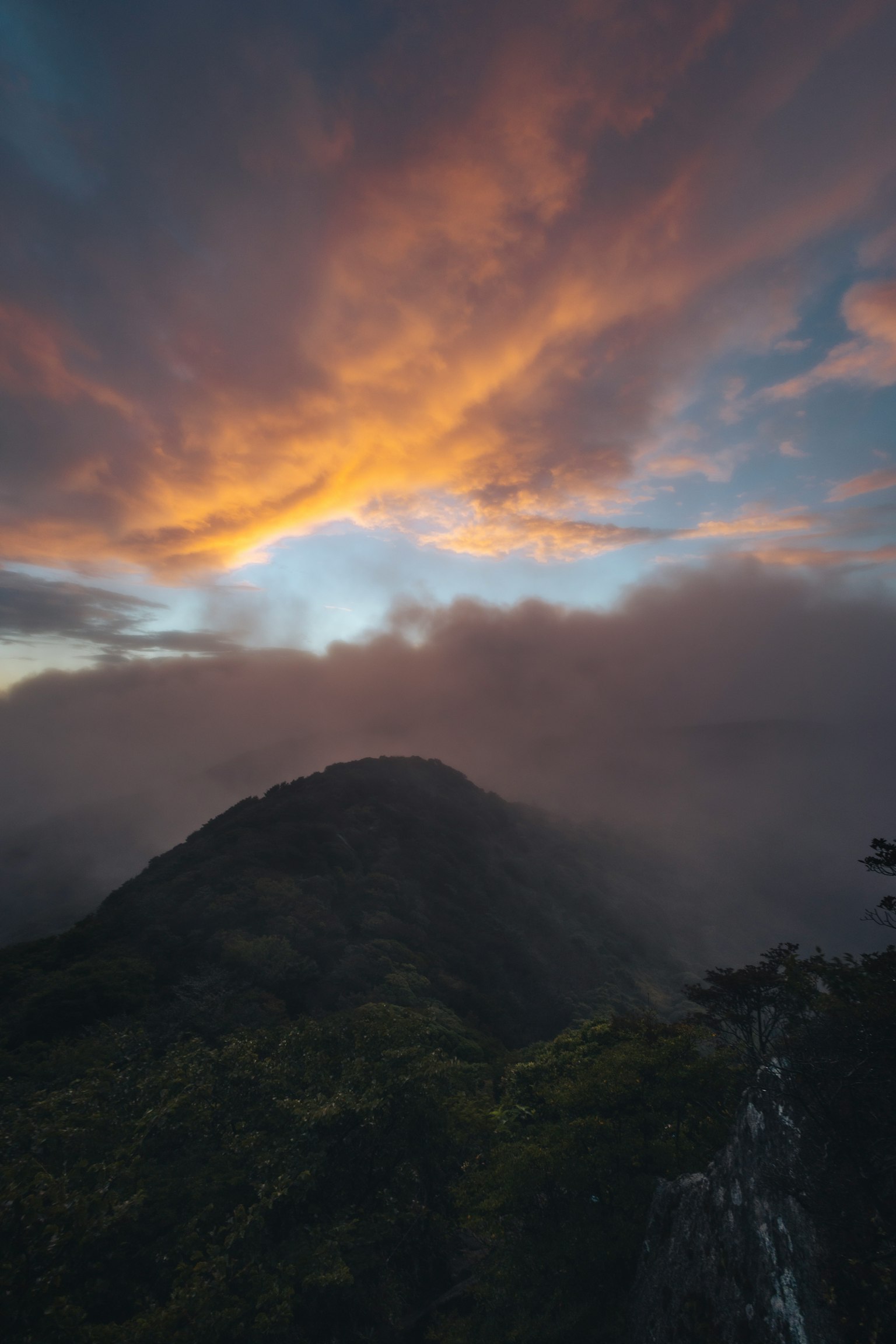 Nuvole e cielo al tramonto sopra una cima di montagna