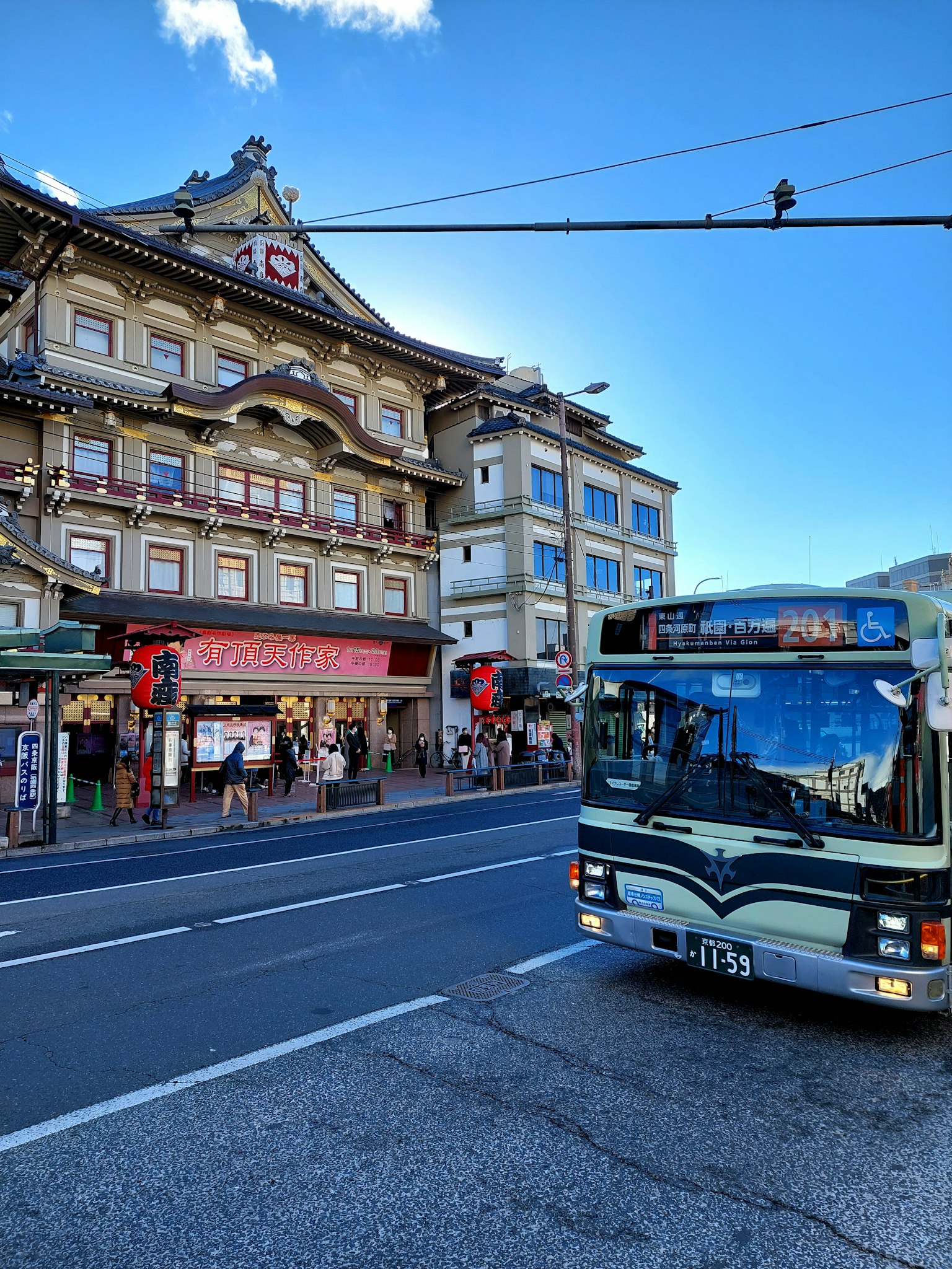 Un autobus che percorre la strada con un edificio tradizionale sullo sfondo