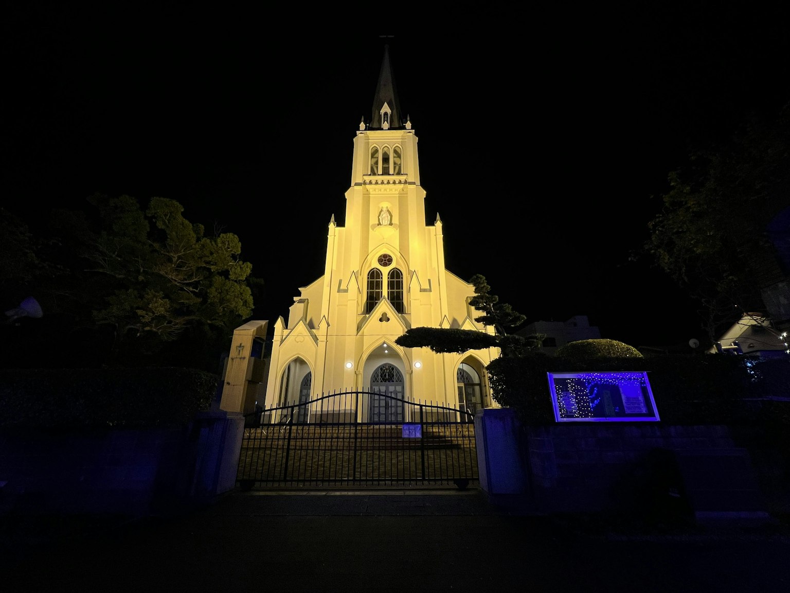Hermosa fachada de una iglesia de noche con iluminación azul