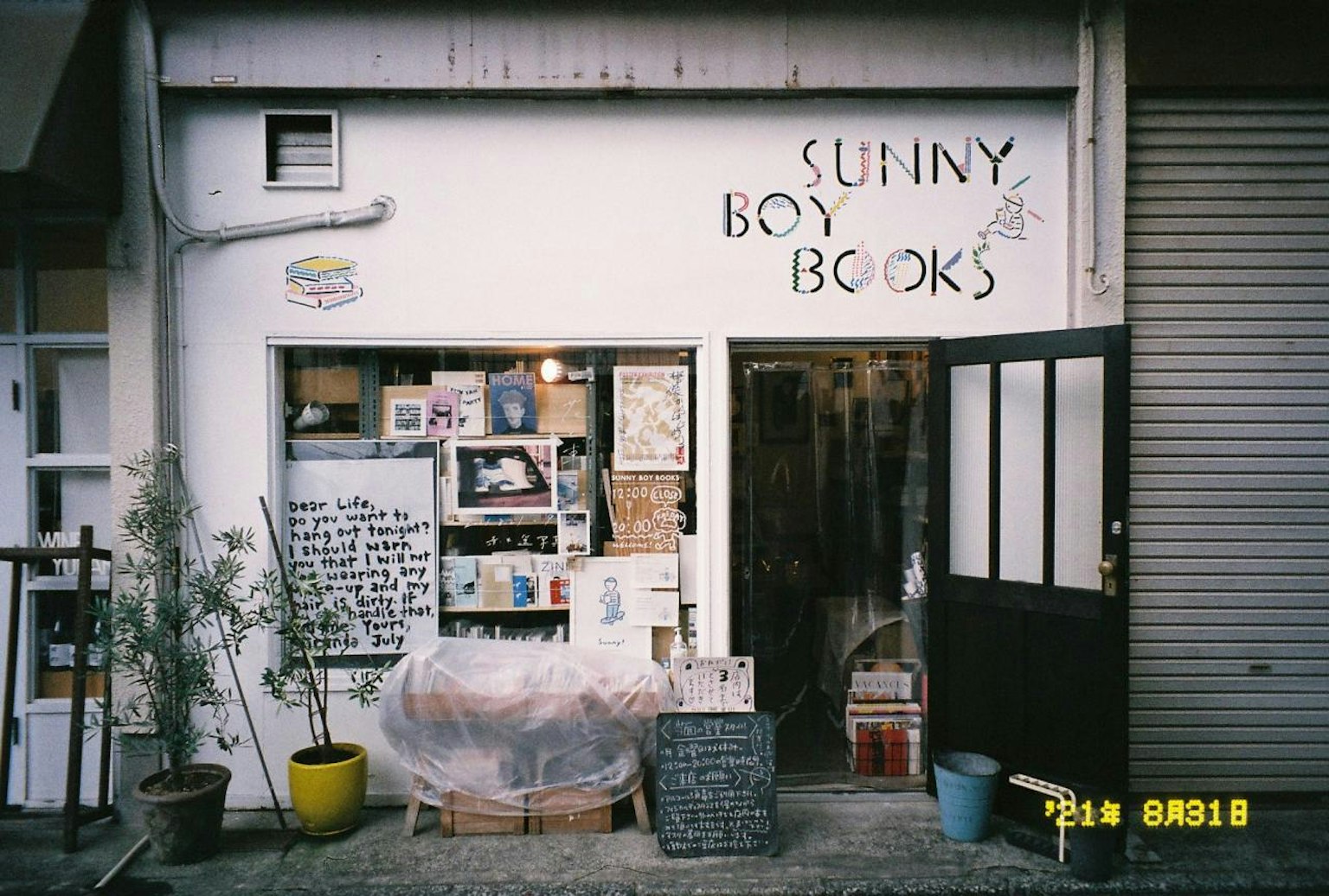 Esterno di Sunny Boy Books piccola libreria con vari espositori di libri