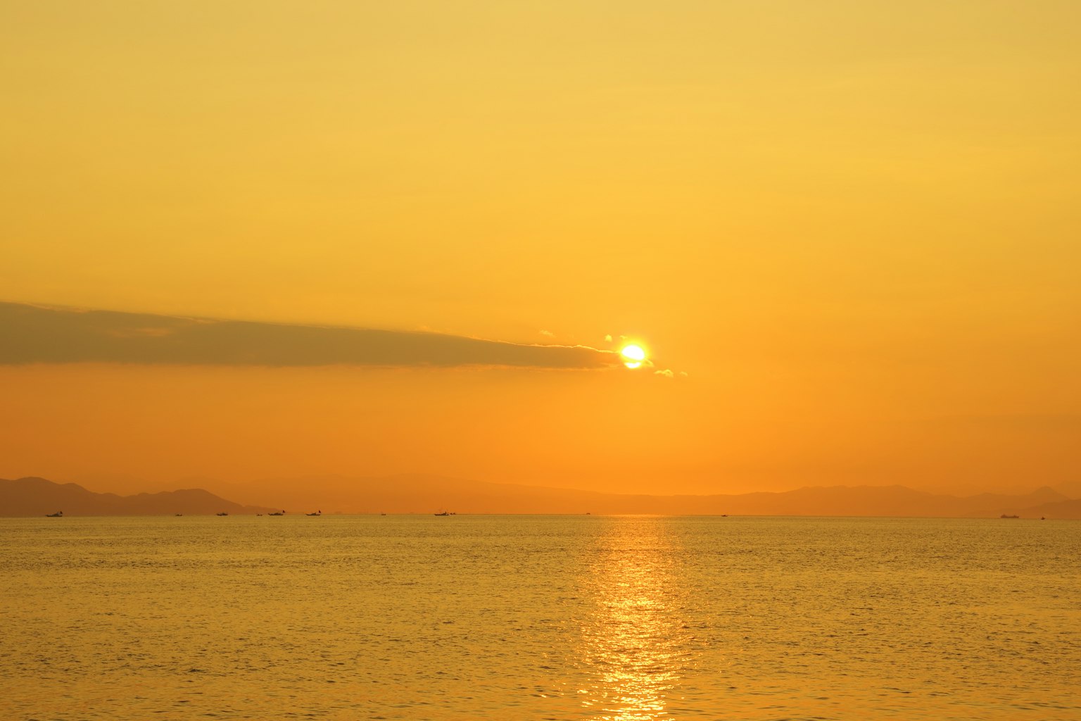 Sonnenuntergang über dem Ozean mit orangefarbenem Himmel und ruhigem Wasser