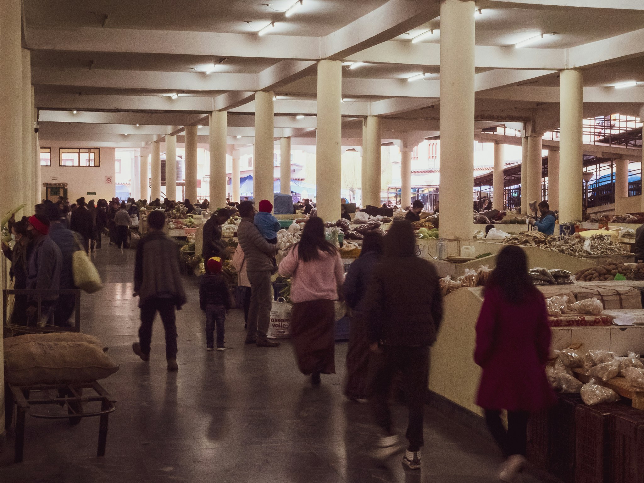 people walking inside a spacious warehouse with columns