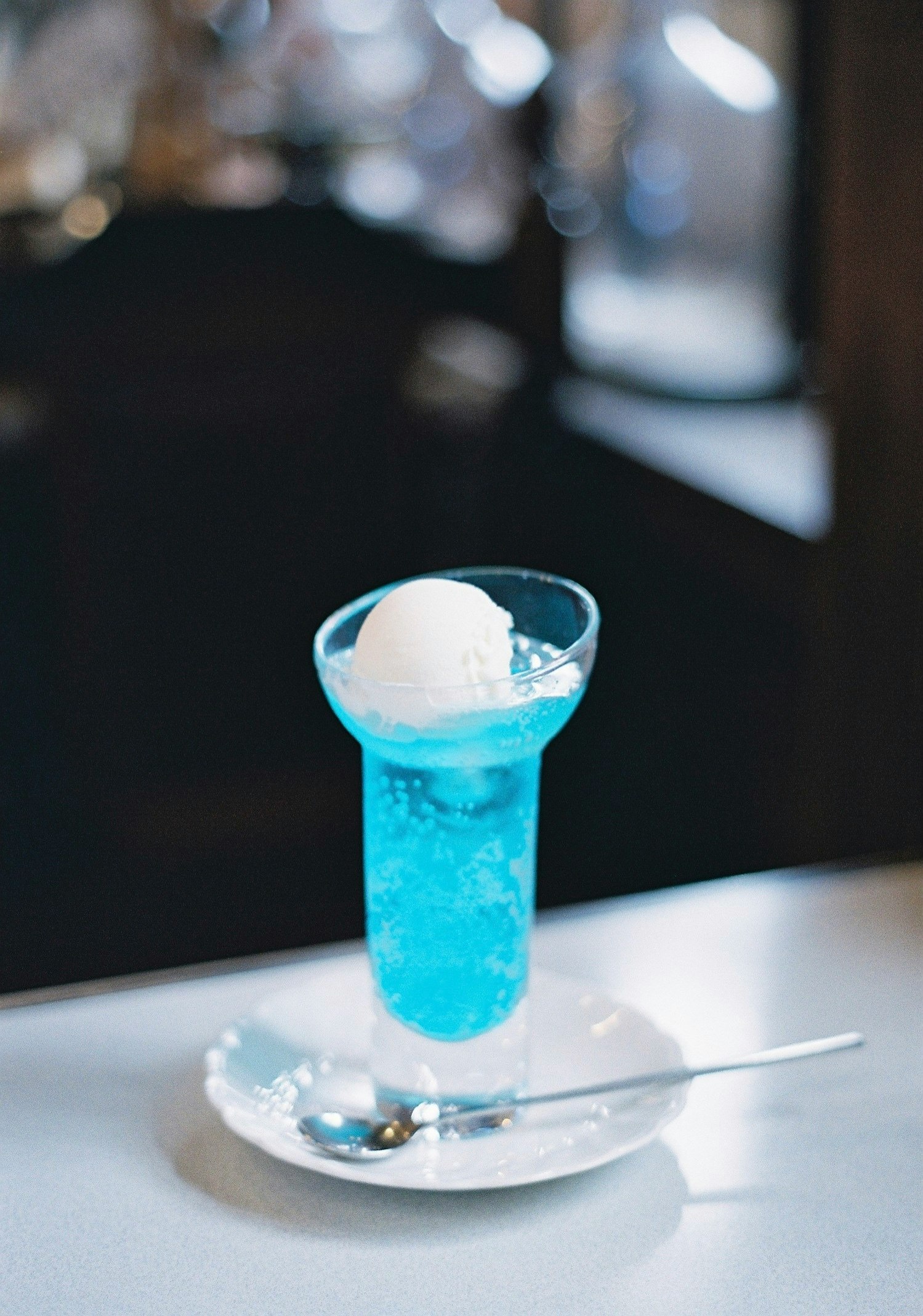 blue cocktail glass with ice on a table
