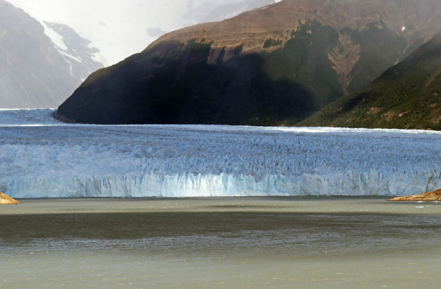 Paysage magnifique d'un glacier se déversant dans un lac entouré de montagnes