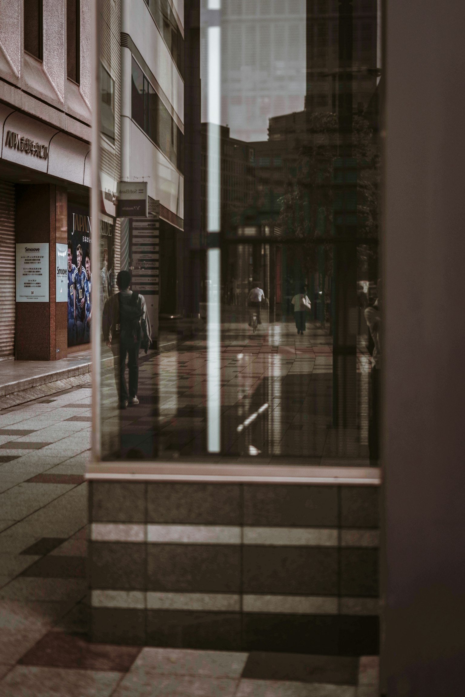Reflet d'une fenêtre de bâtiment montrant des piétons dans un cadre urbain