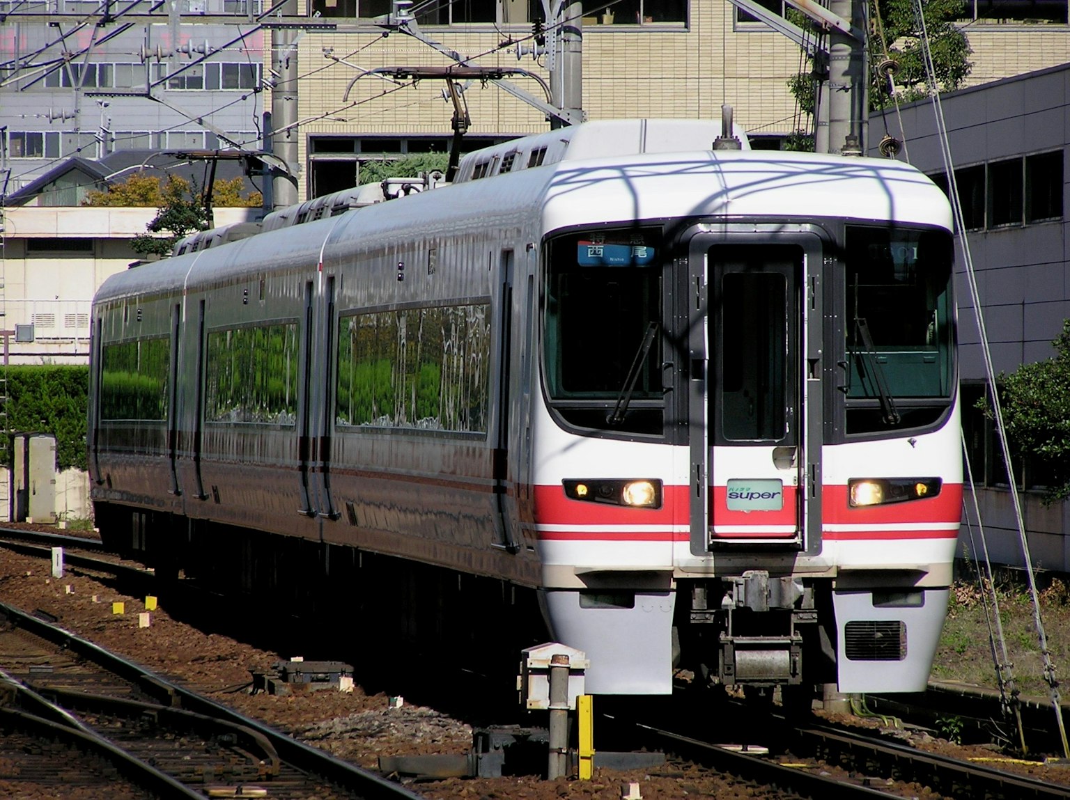 Un treno bianco e rosso sta viaggiando sui binari