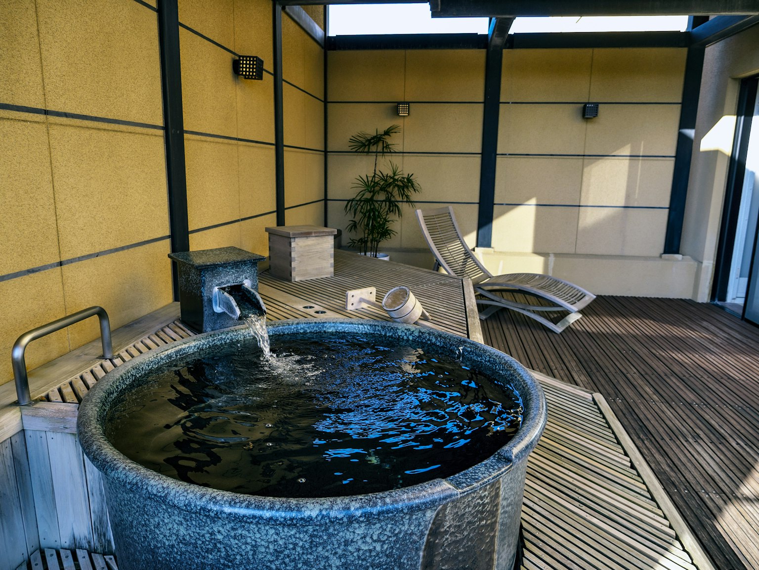 Dach-Spa-Bereich mit einem runden Whirlpool und einem Liegestuhl