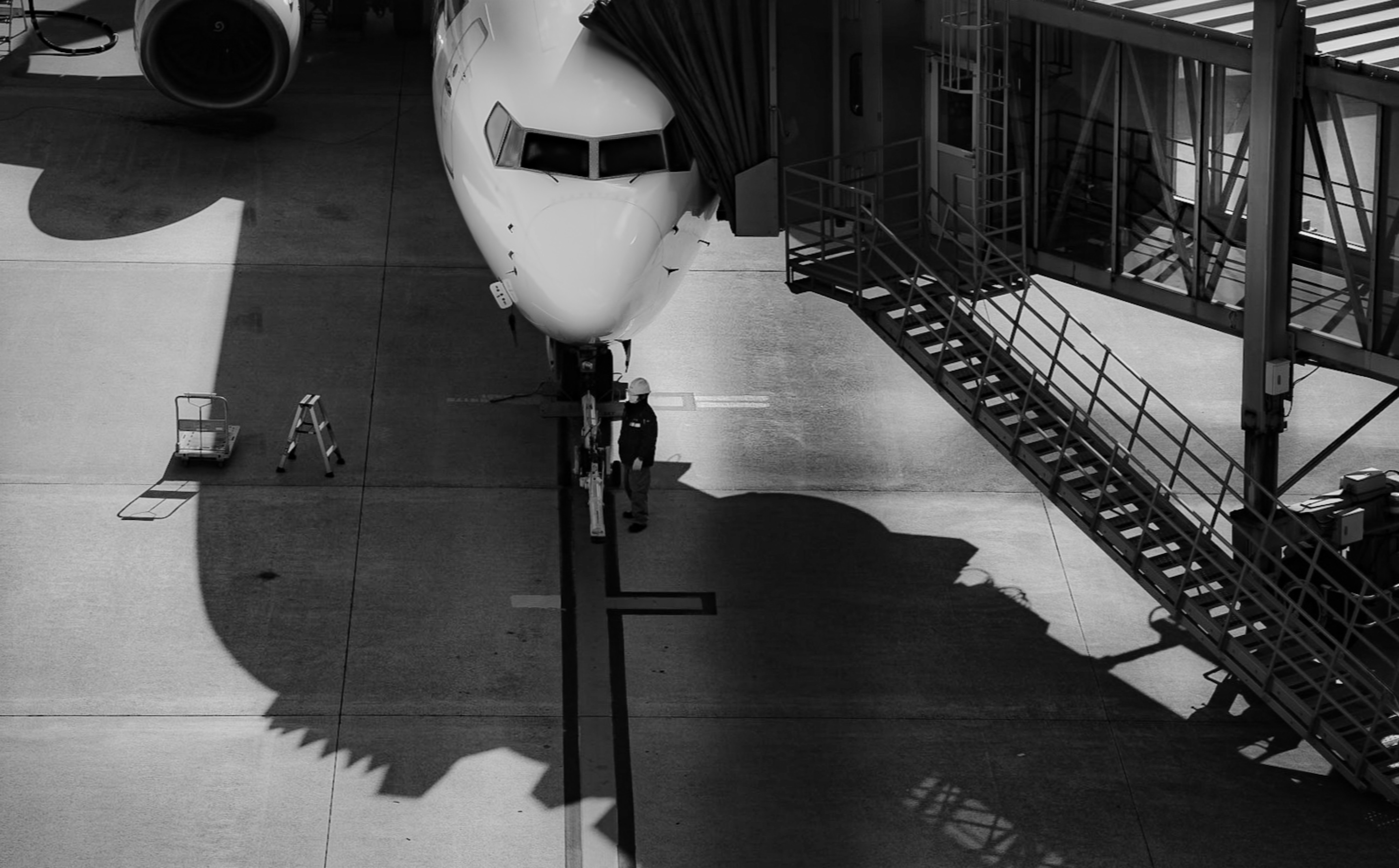 滑走路上の飛行機と影のモノクロ風景