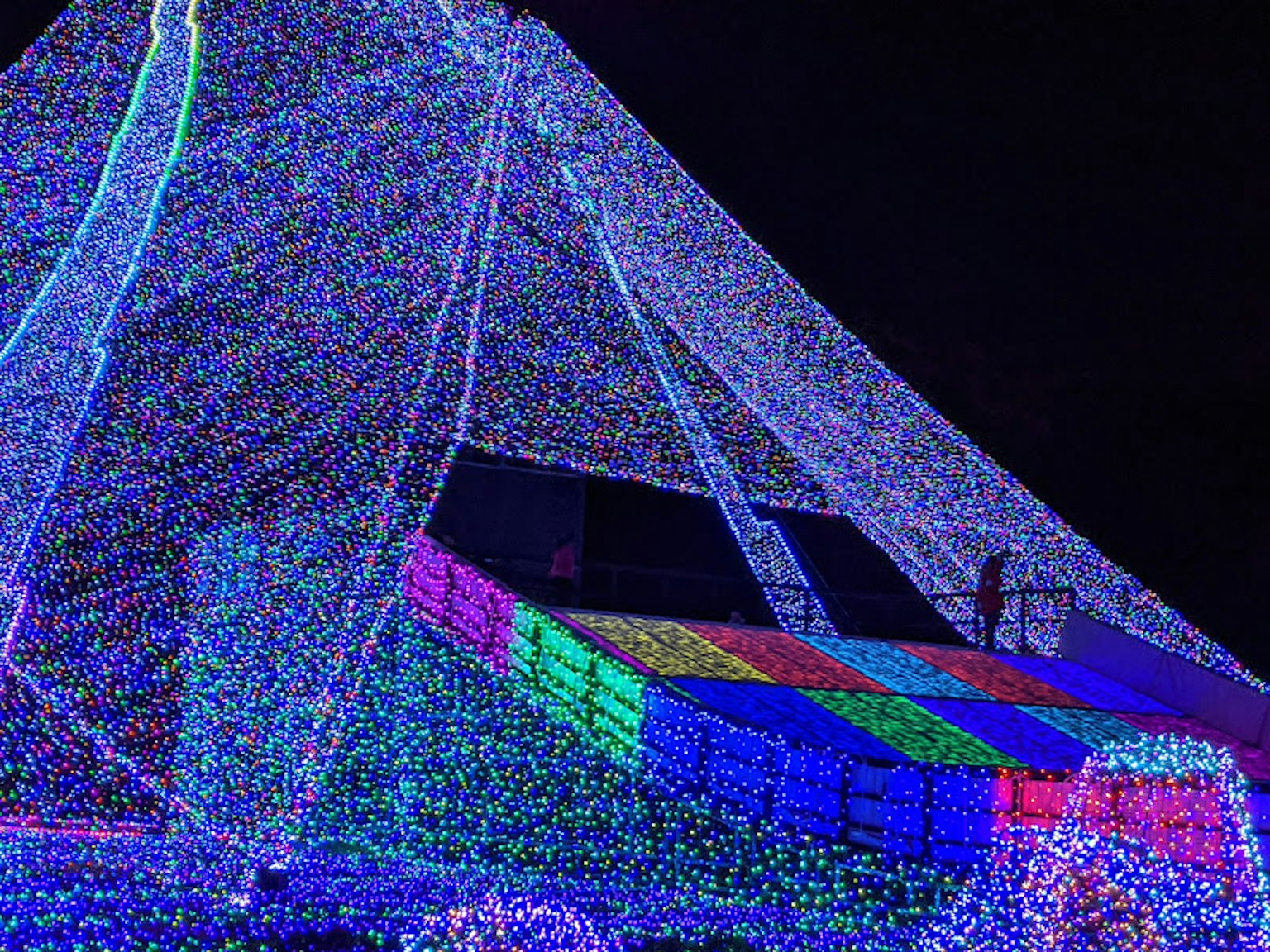 Lumières colorées décorant une tente contre un ciel sombre