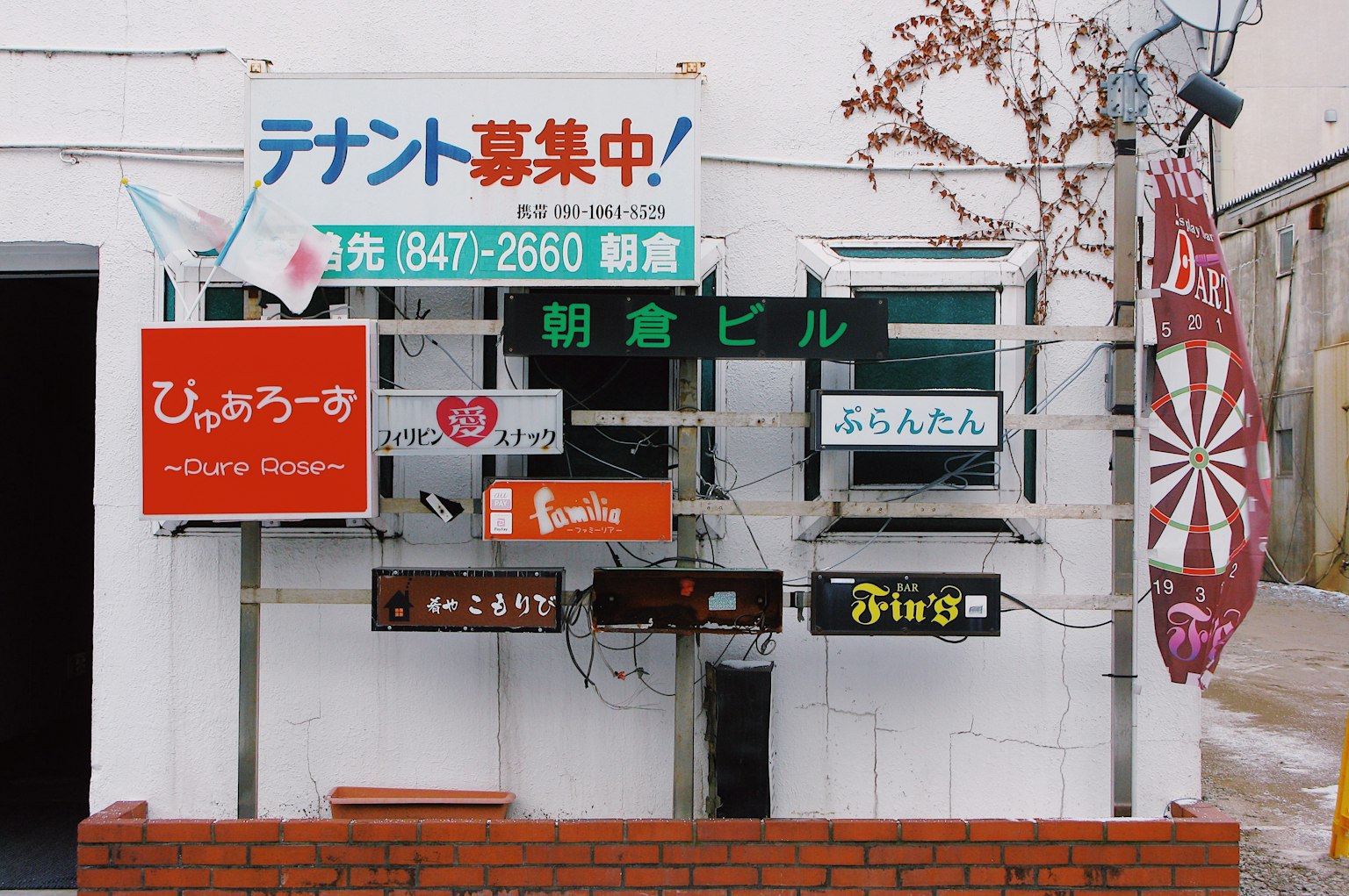 A wall displaying multiple colorful signs and advertisements for different businesses