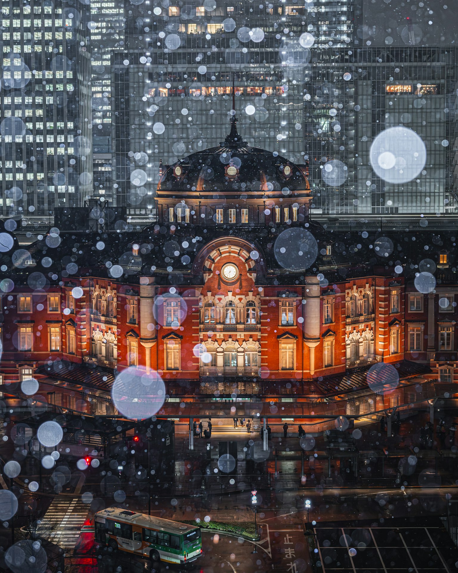 Belle vue nocturne de la gare de Tokyo illuminée dans la neige bâtiment historique contrastant avec des gratte-ciels modernes