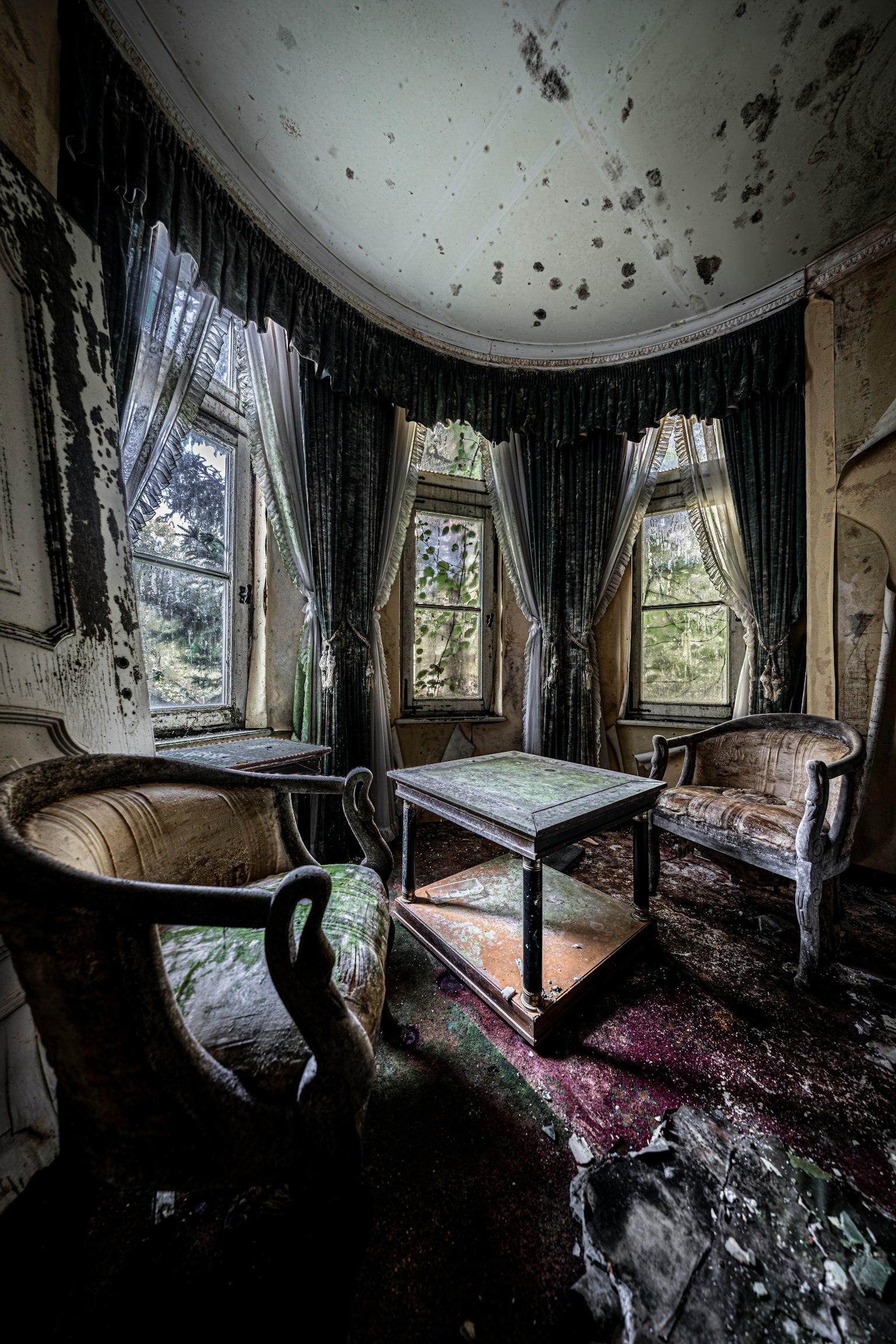 古びた部屋にある二つの椅子とテーブル 窓から自然光が差し込む 壁は剥がれかけている