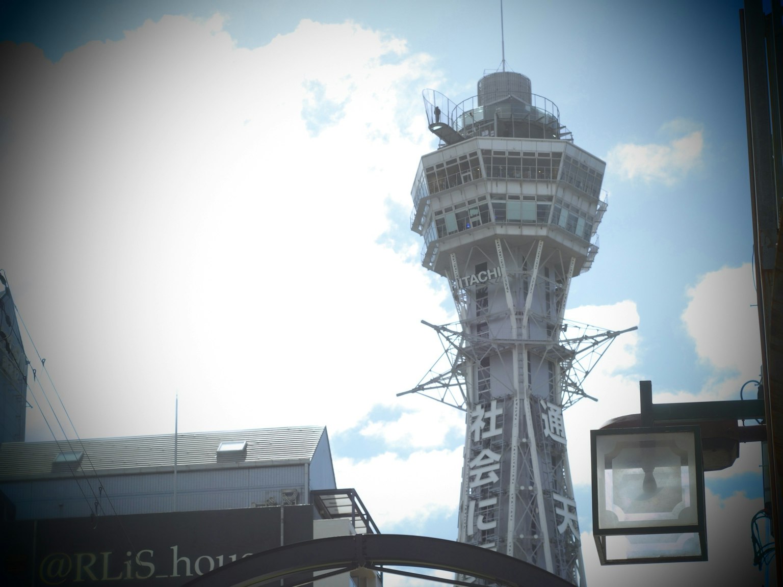 Gambar dekat Menara Tsutenkaku di Osaka dengan latar belakang langit biru dan awan