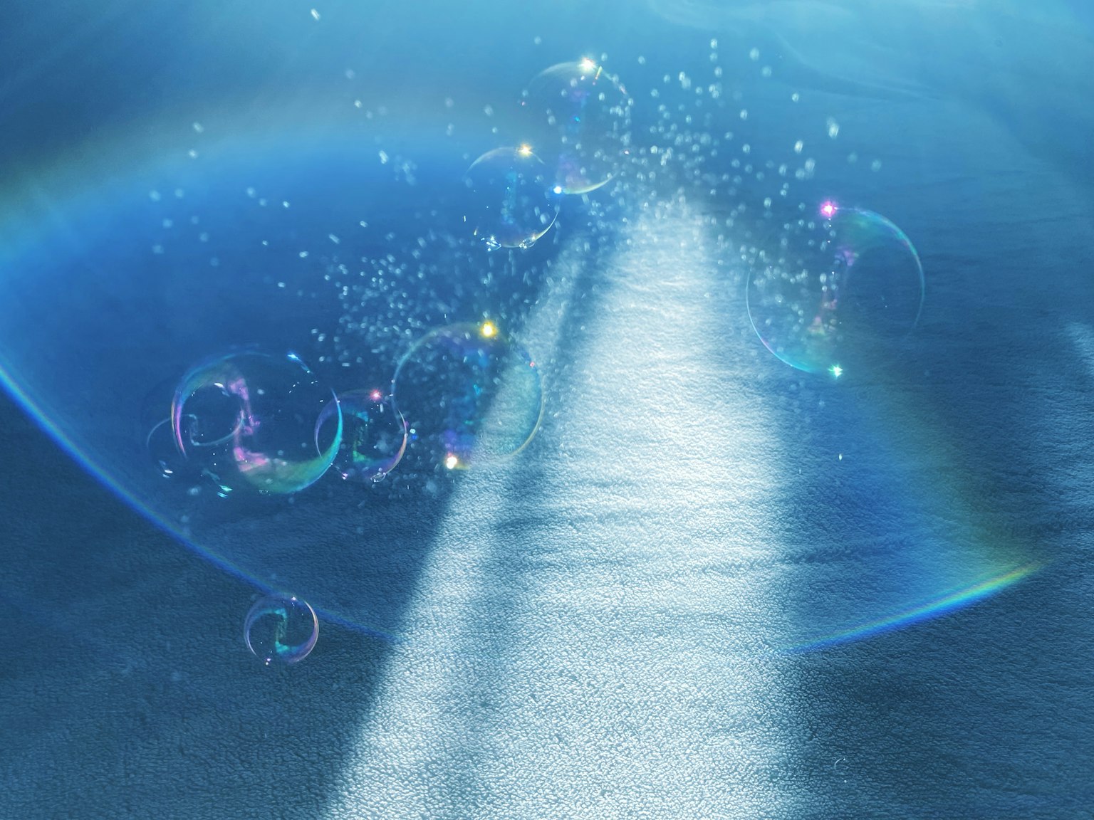 Un chemin de lumière sur une surface bleue avec des bulles et des étincelles