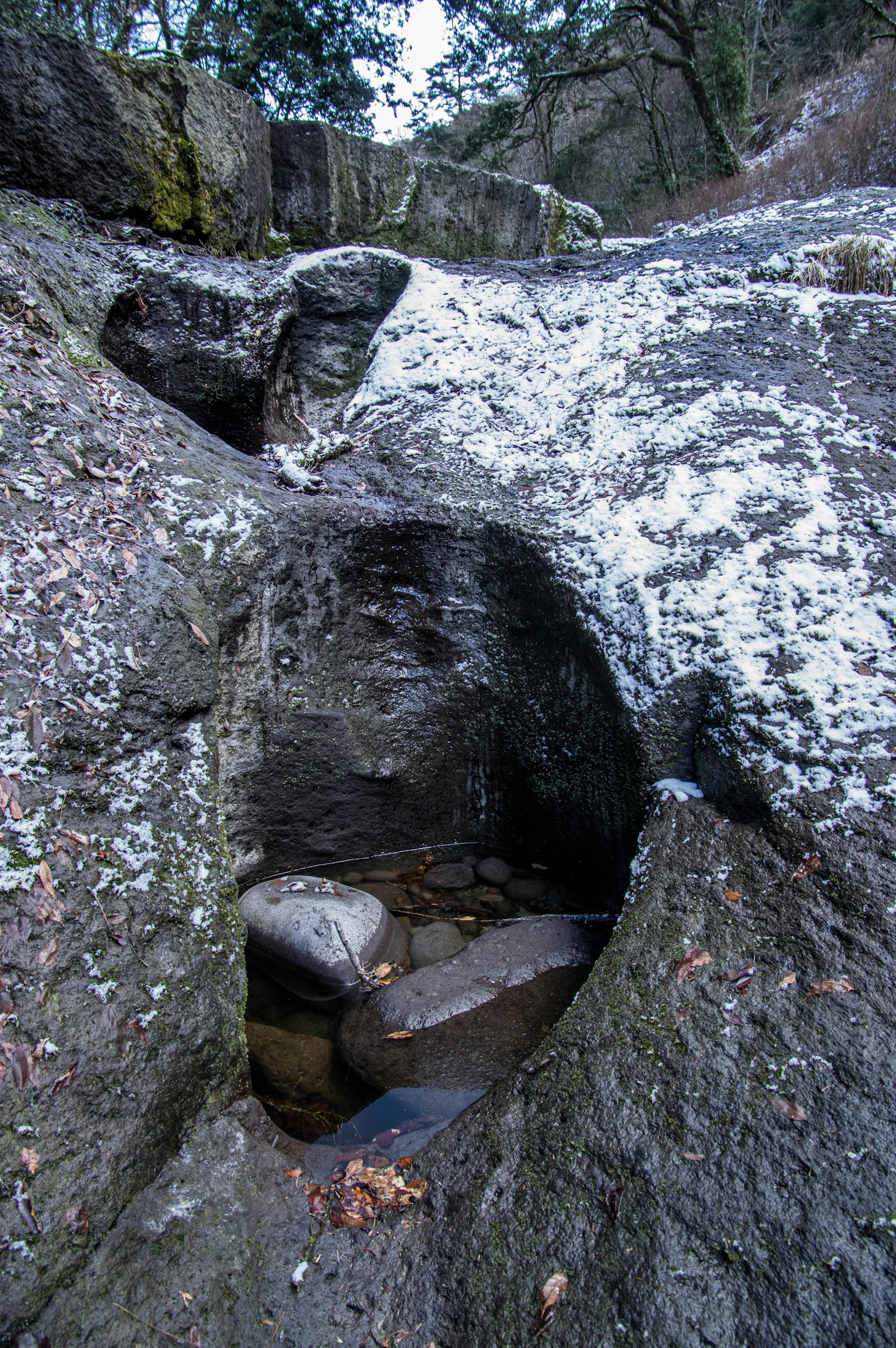 A small puddle of water between rocks in a natural setting
