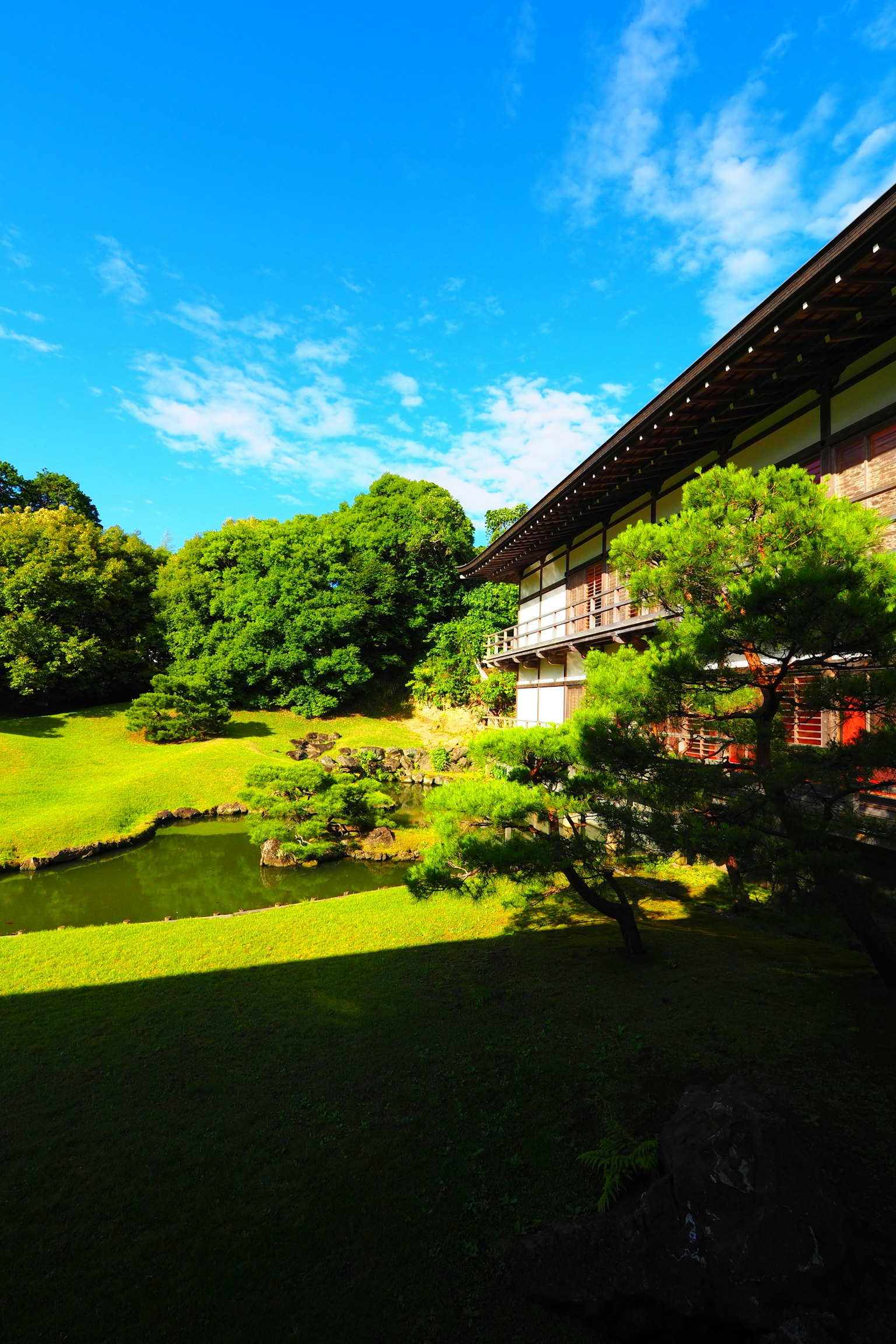 Edificio tradizionale con giardino lussureggiante e cielo blu