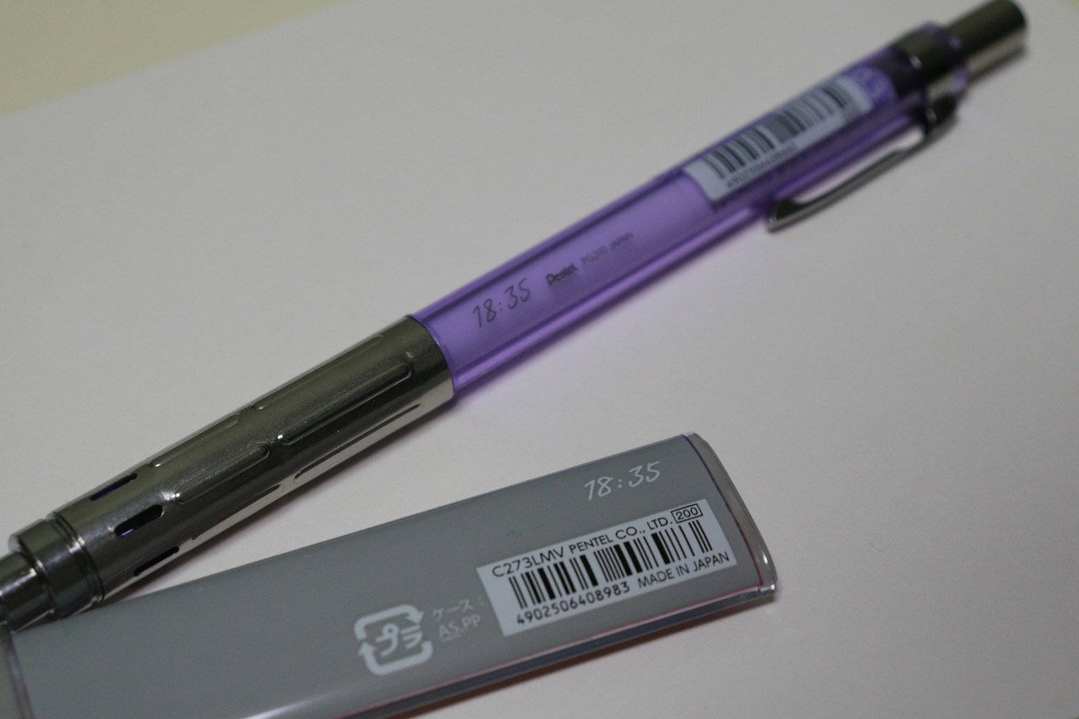 ปากกาสีม่วงและยางลบสีเทาบนพื้นหลังสีขาว