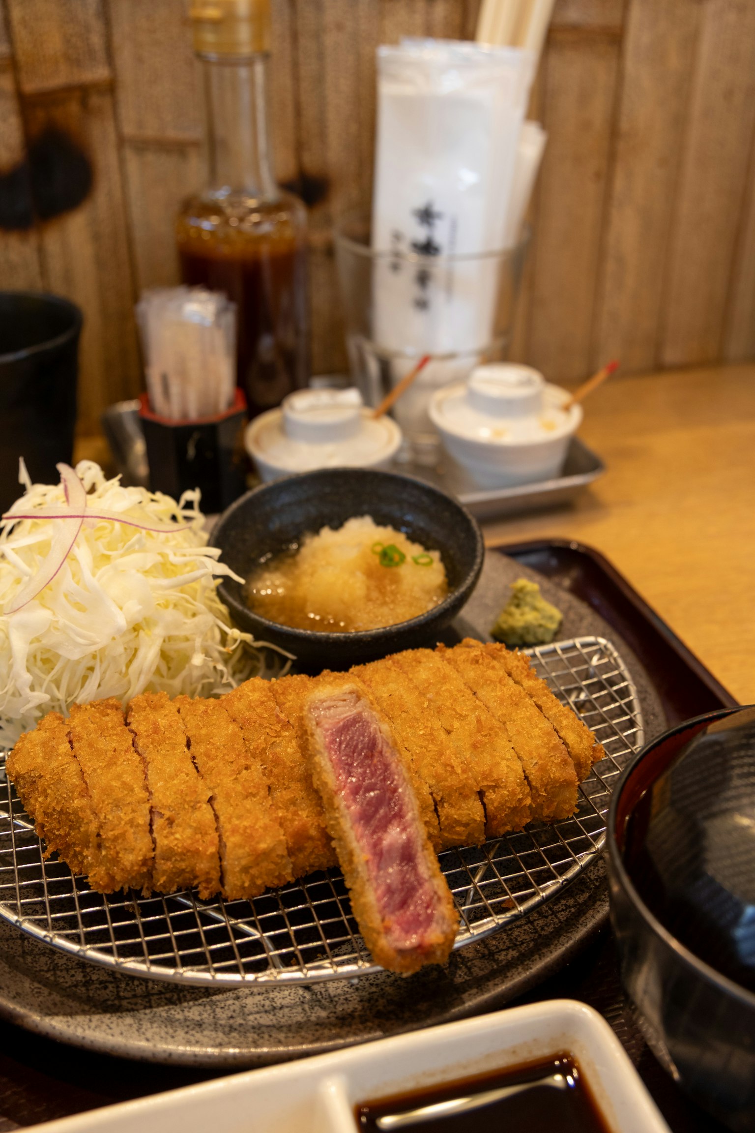 Tonkatsu jugoso servido con repollo rallado y salsa para mojar