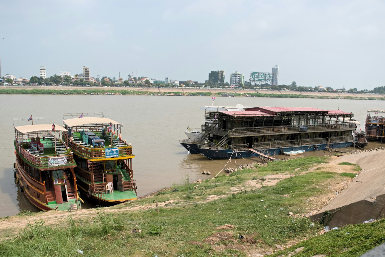 Bunte Boote am Ufer mit modernen Gebäuden im Hintergrund