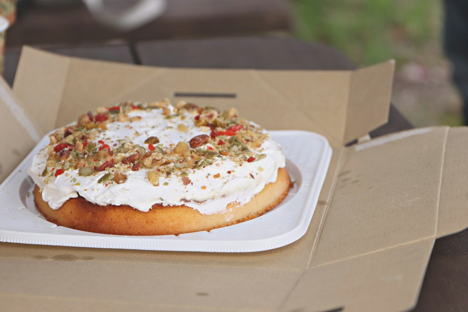 Ein Kuchen mit Sahne und Nüssen in einer Takeout-Box