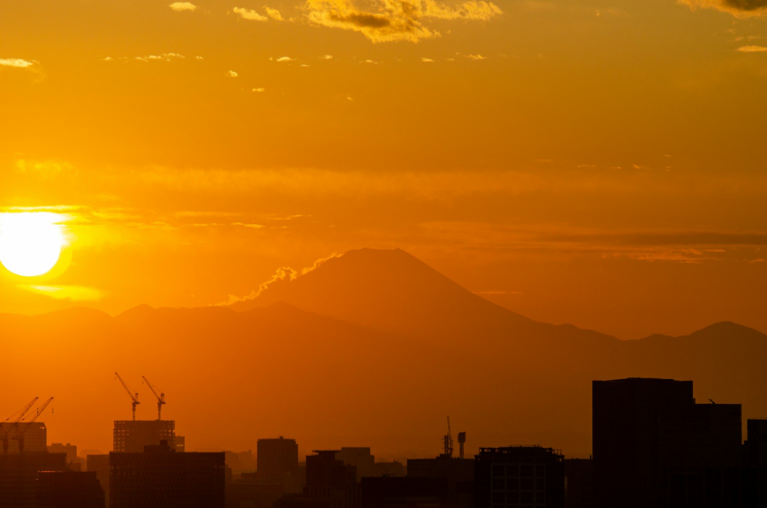Sunset view with mountains and city silhouette